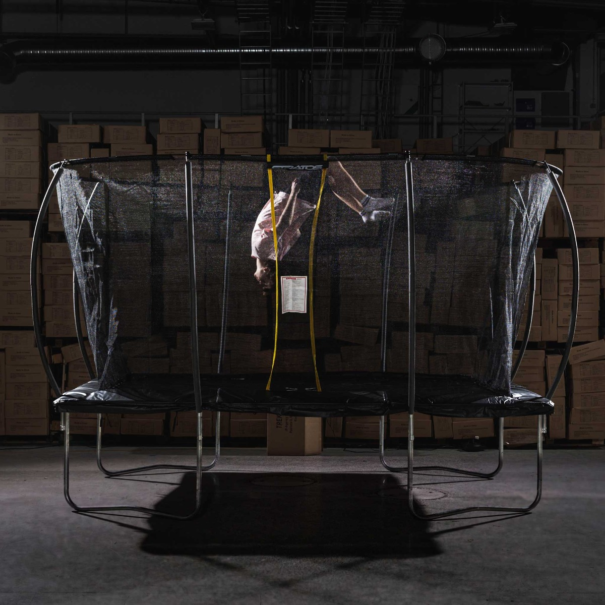 Osoba robi salto na trampolinie.