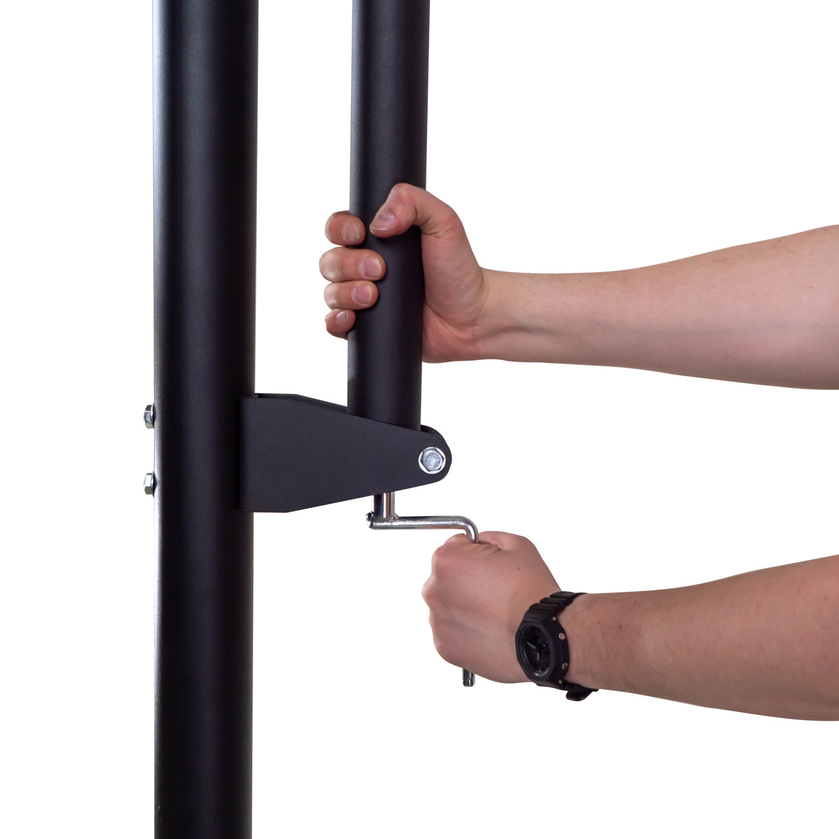 Dwie ręce trzymają czarny metalowy pręt, dokręcając śrubę kluczem. Czarne tło.