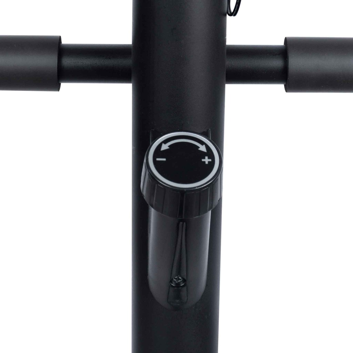 Zbliżenie czarnego pokrętła ze znakami plus i minus, prawdopodobnie do regulacji oporu w maszynie do ćwiczeń.