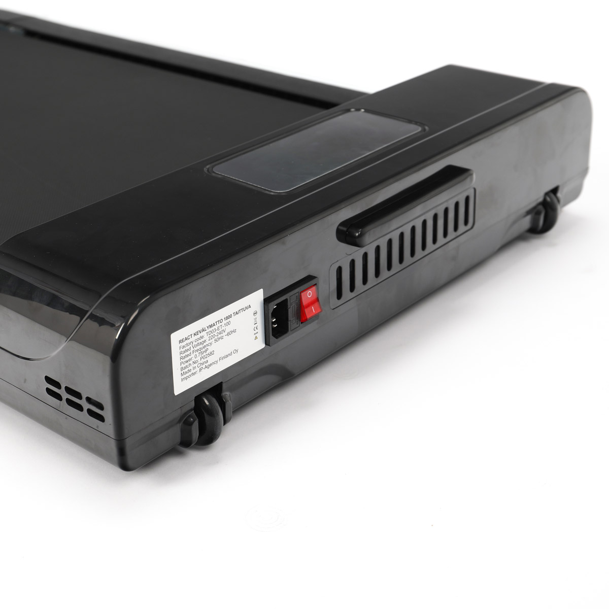 Czarna podstawa bieżni z czerwonym przyciskiem zasilania i kółkami z boku. Białe tło.