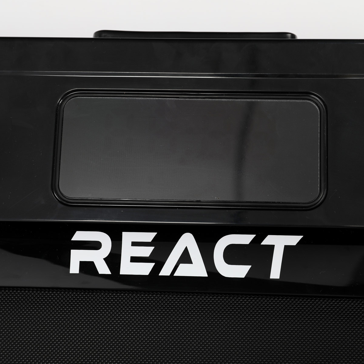 Czarny pojemnik z białym napisem "REACT". W pojemniku znajduje się prostokątny otwór.