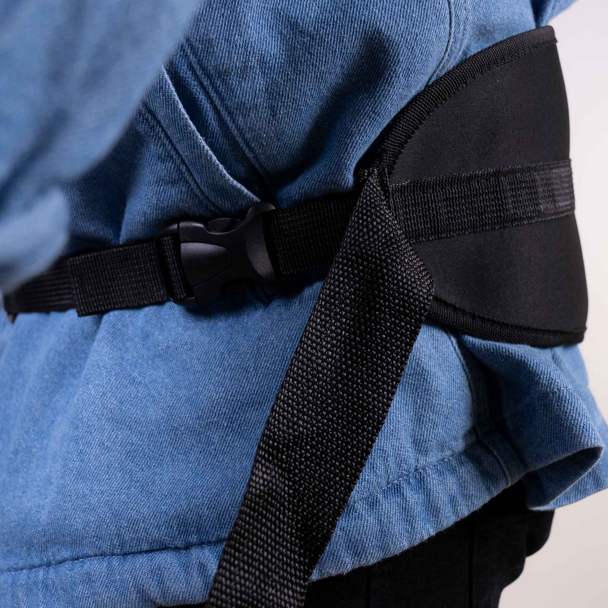 Osoba nosząca dżinsową kurtkę z czarnym paskiem wokół talii. Białe tło.