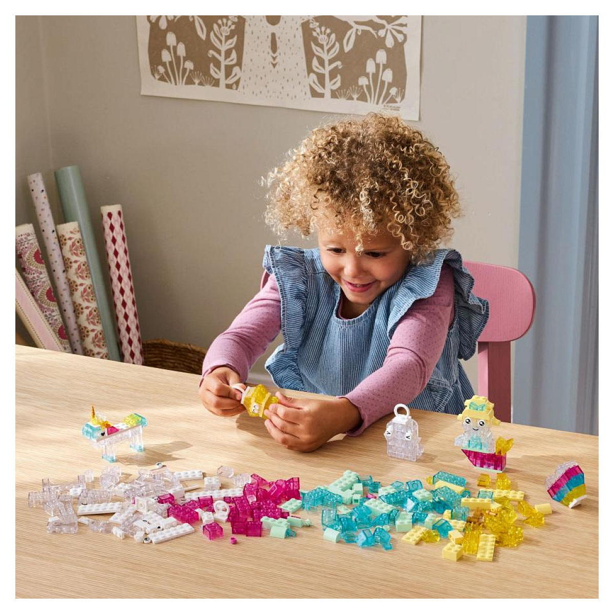 Dziecko bawi się kolorowymi klockami Lego, w tym jednorożcem i figurkami syren.