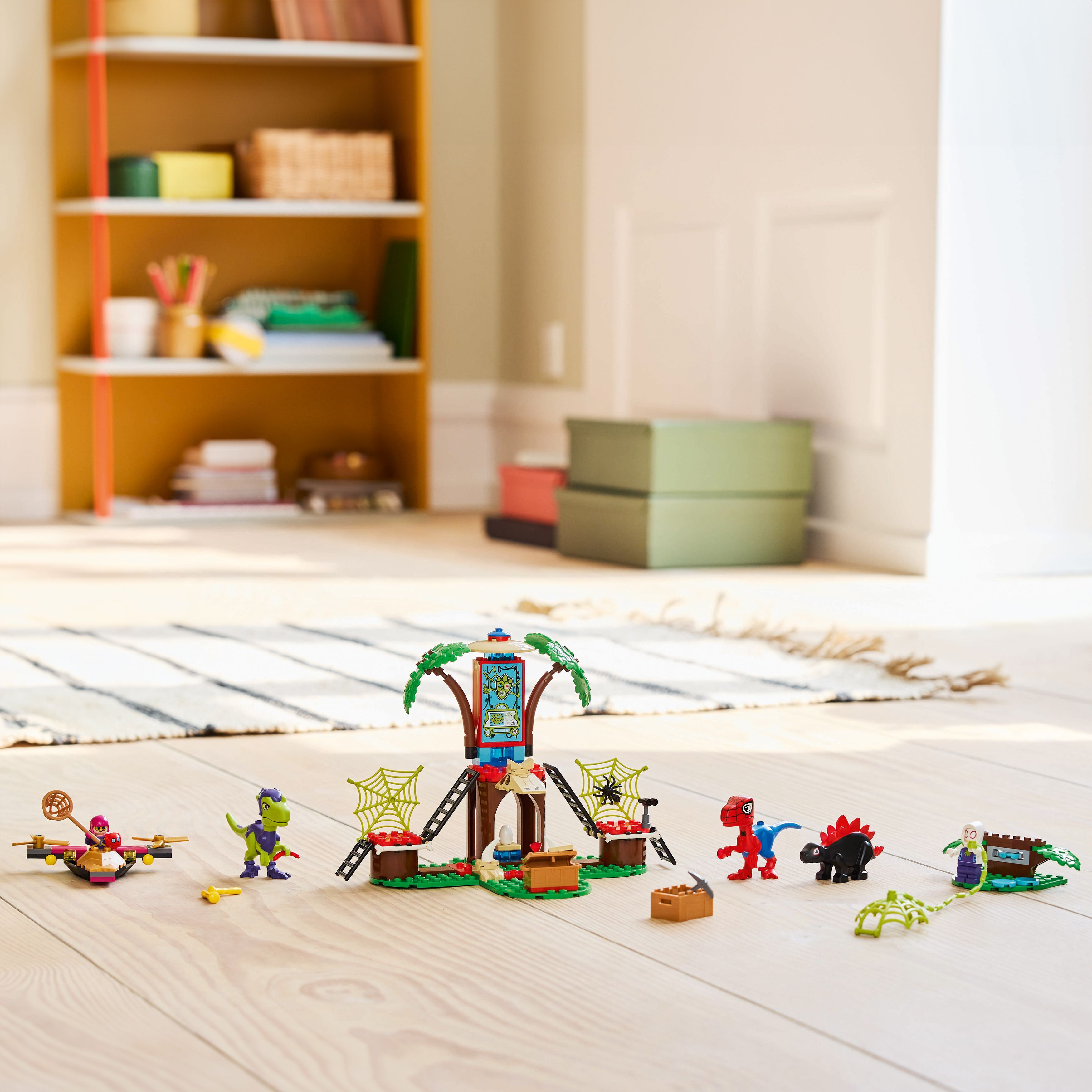 Scena Lego z dinozaurami. Dinozaury, figurki i drewniana konstrukcja w pokoju.