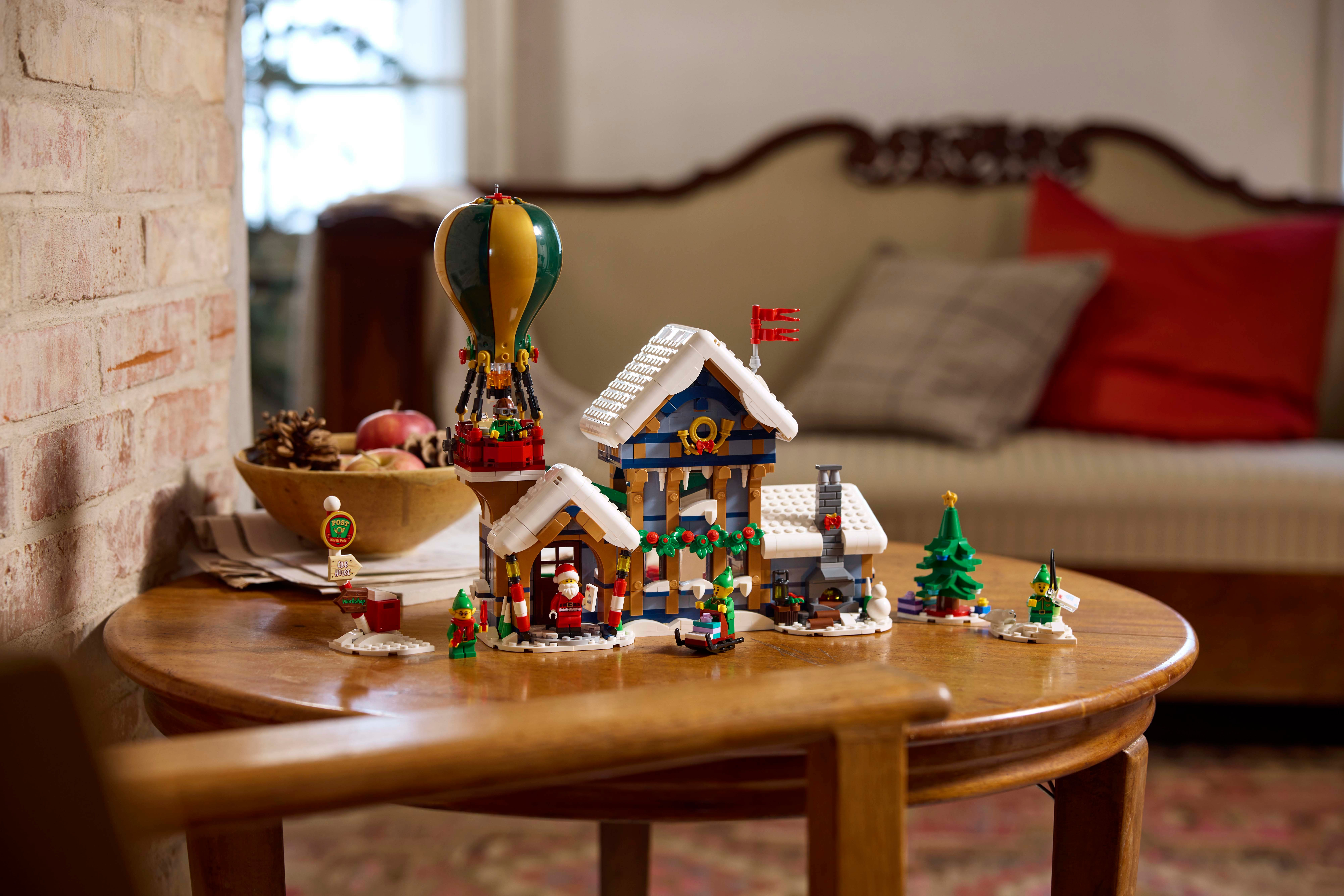Set natalizio Lego su un tavolo: piccoli edifici, una mongolfiera e un albero di Natale.