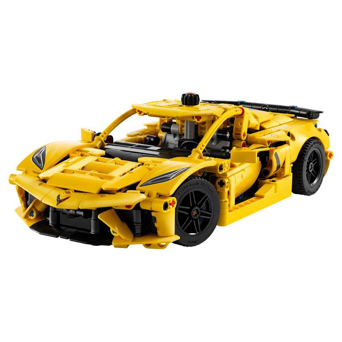 Un modelo de coche deportivo Lego amarillo con ruedas negras, sobre una superficie blanca.