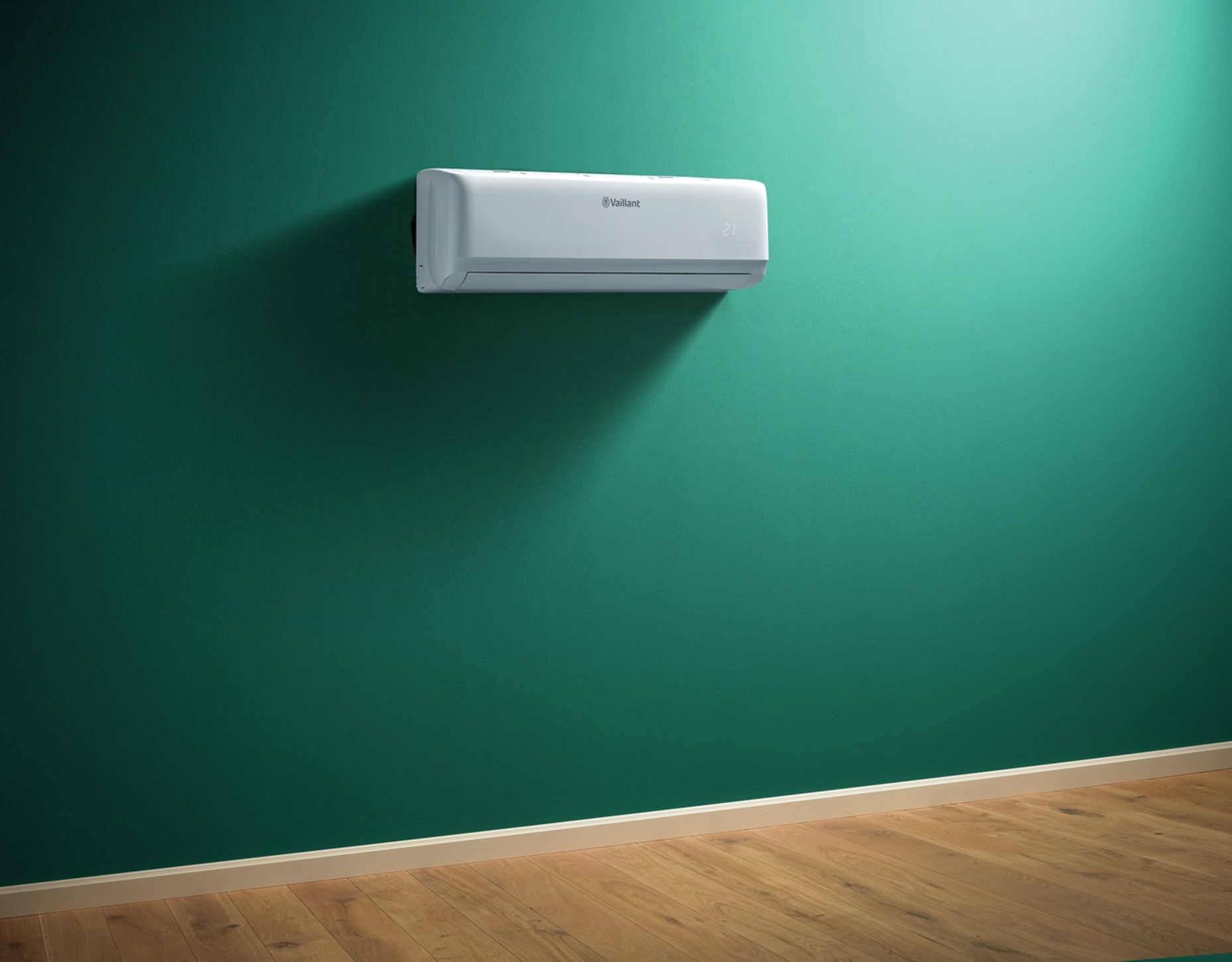 Condizionatore montato su parete verde, con pavimento in legno. Il logo Vaillant è visibile.
