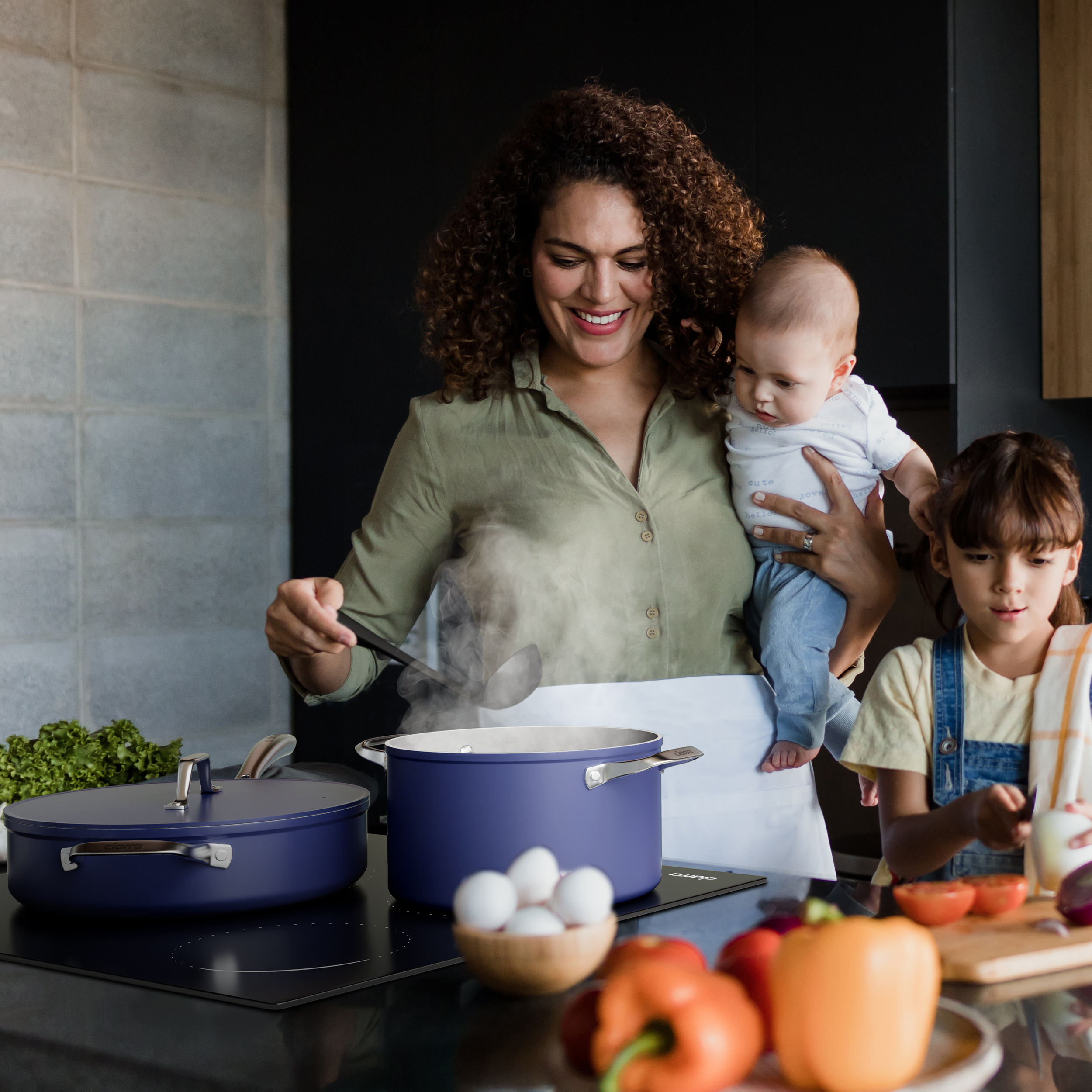 Woman cooks with kids. A pot on the stove, vegetables are on the table.