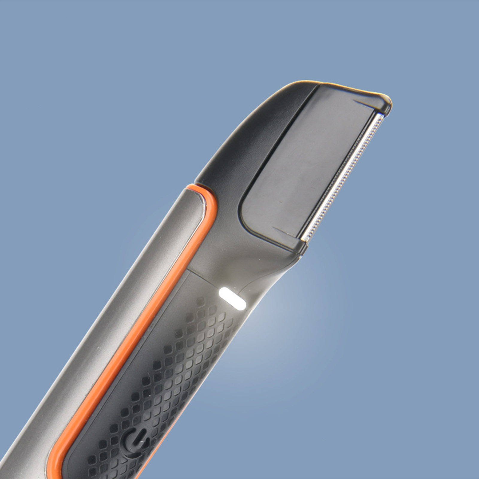 Schwarzer und grauer Trimmer. Er hat orangefarbene Details und ein Licht. Blauer Hintergrund.