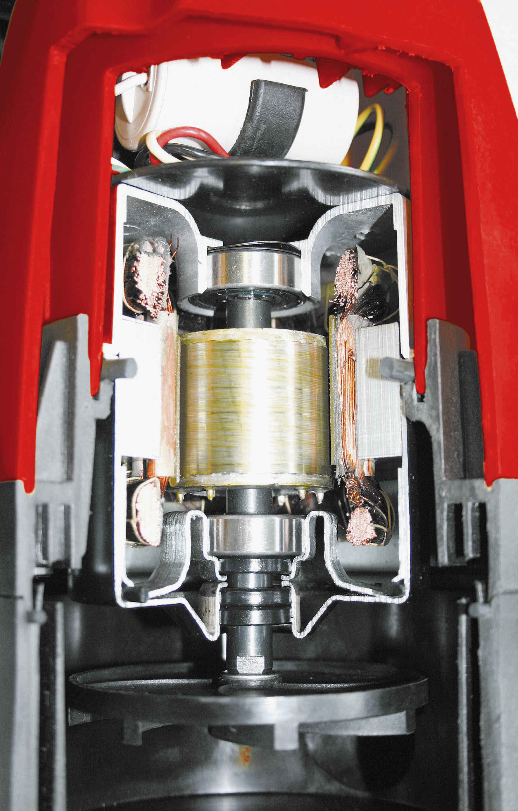 Coupe d'une perceuse rouge montrant les composants internes et le moteur.