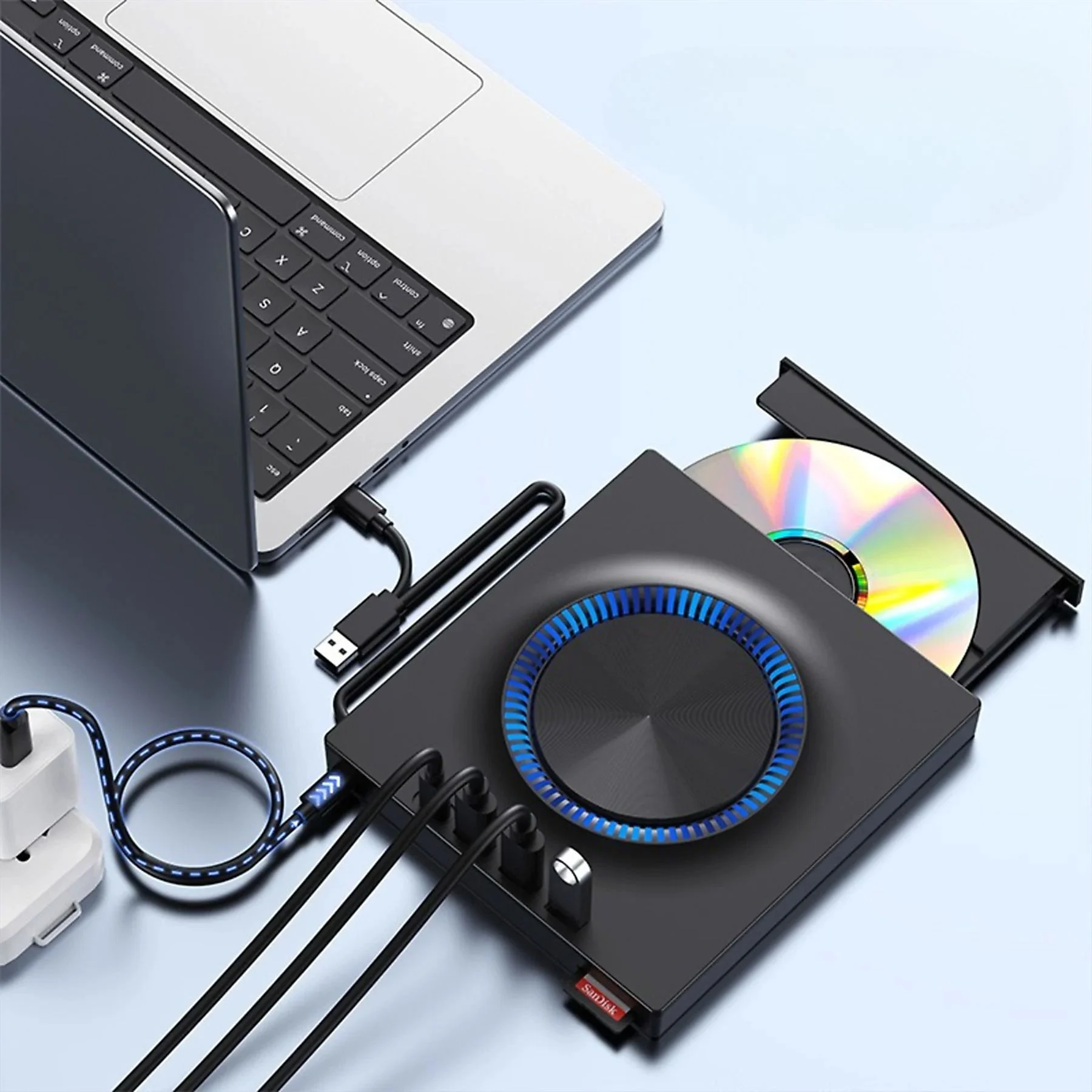 Laptop, der mit einem schwarzen Gerät verbunden ist. Eine CD befindet sich darin. Viele Kabel angeschlossen.