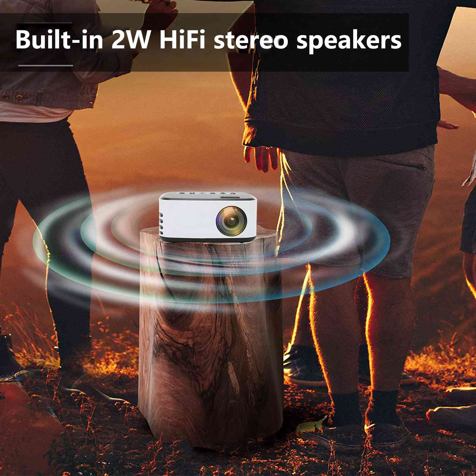 Weißer Projektor auf einem Holzstumpf mit Personen im Hintergrund. Text: Eingebaute 2W HiFi-Stereolautsprecher.