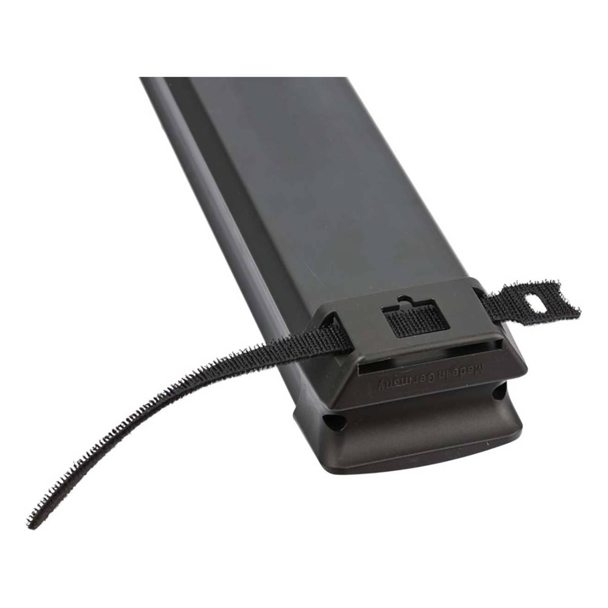 Primo piano di un dispositivo nero con cinturino e fibbia su una superficie bianca.