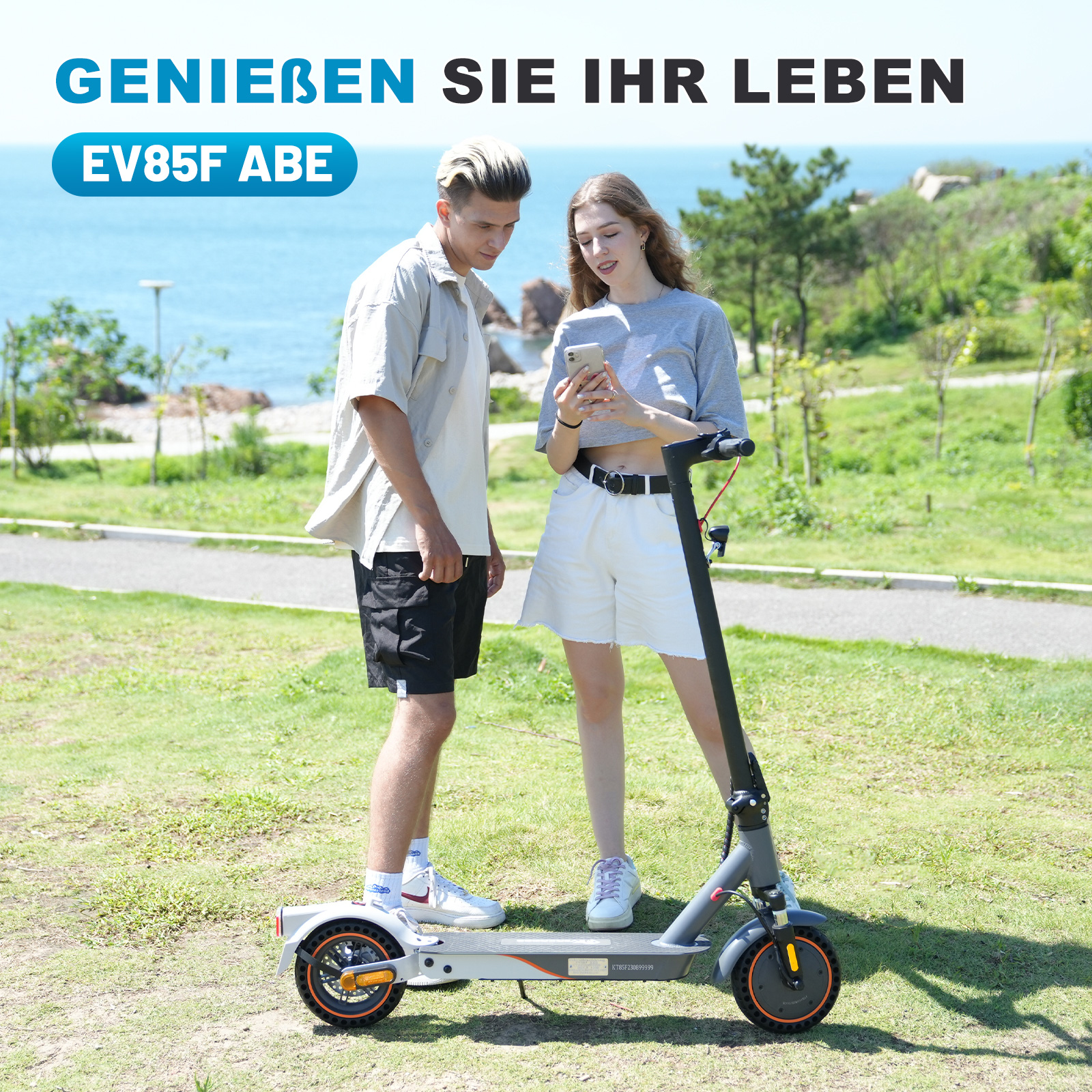 Ein Paar benutzt einen Elektroroller. Sie sind auf einer Wiese mit Meerblick.