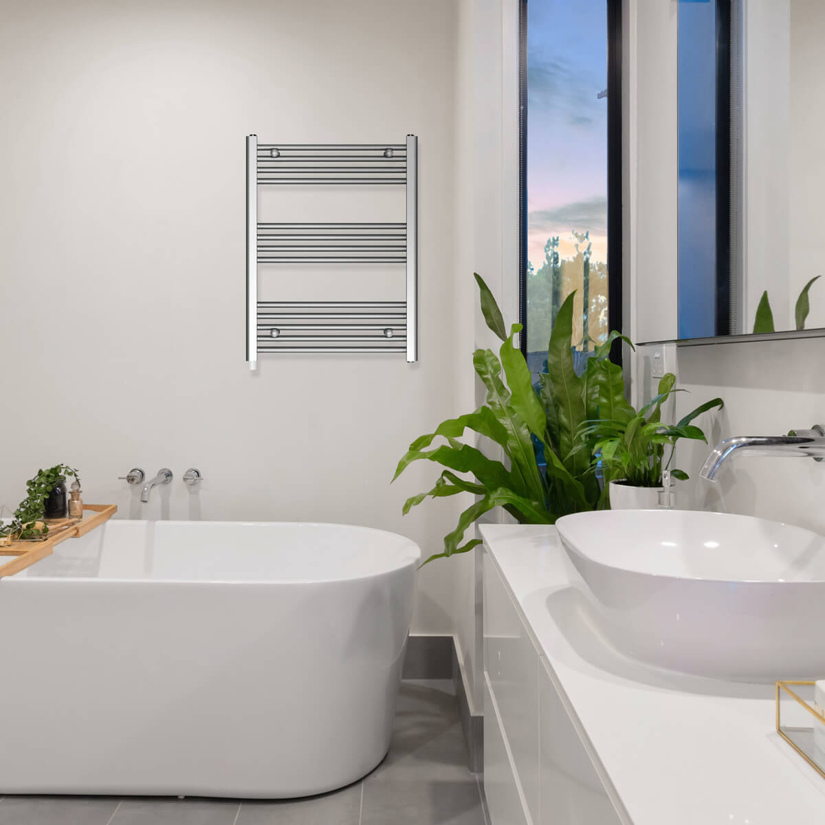 Łazienka z wanną, umywalką, zielenią i wieszakiem na ręczniki.