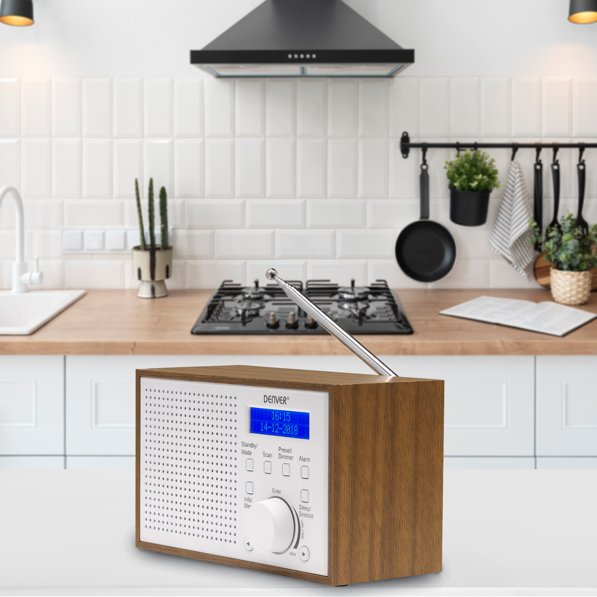 Drewniane radio na białej powierzchni. Pokazuje wyświetlacz i elementy sterujące. Tło kuchni.