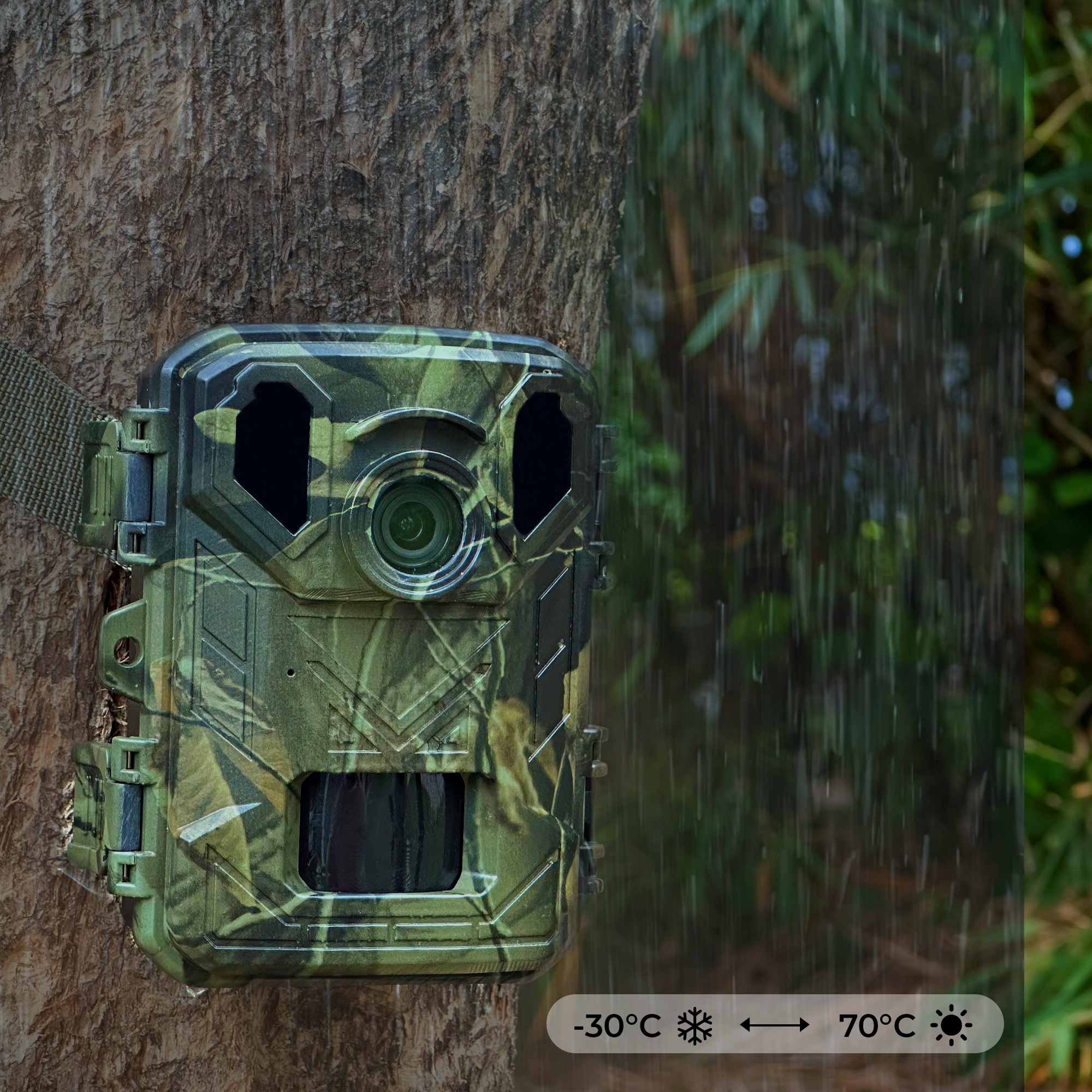 Camouflage camera mounted on a tree with water droplets and temperature range.
