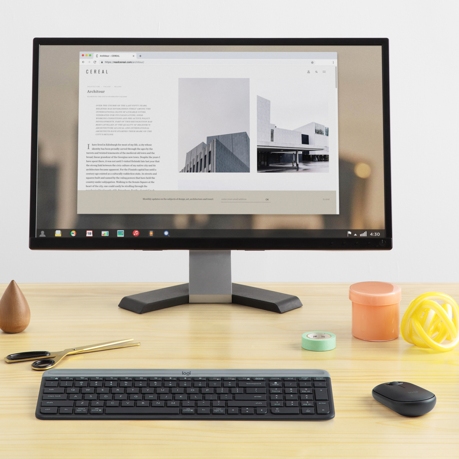 Un monitor de computadora en un escritorio de madera con suministros de oficina.