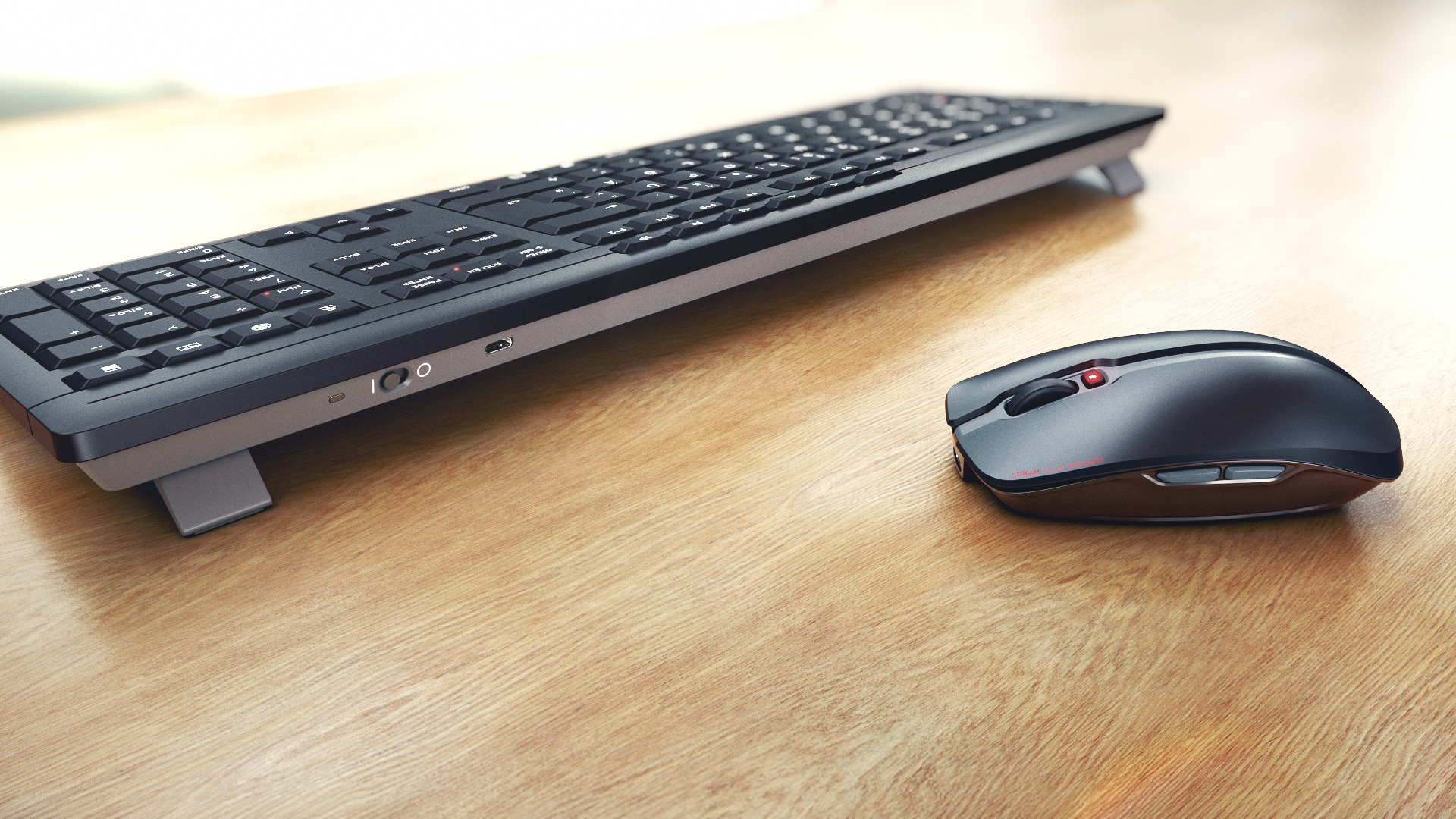 Teclado y ratón negros en escritorio de madera.