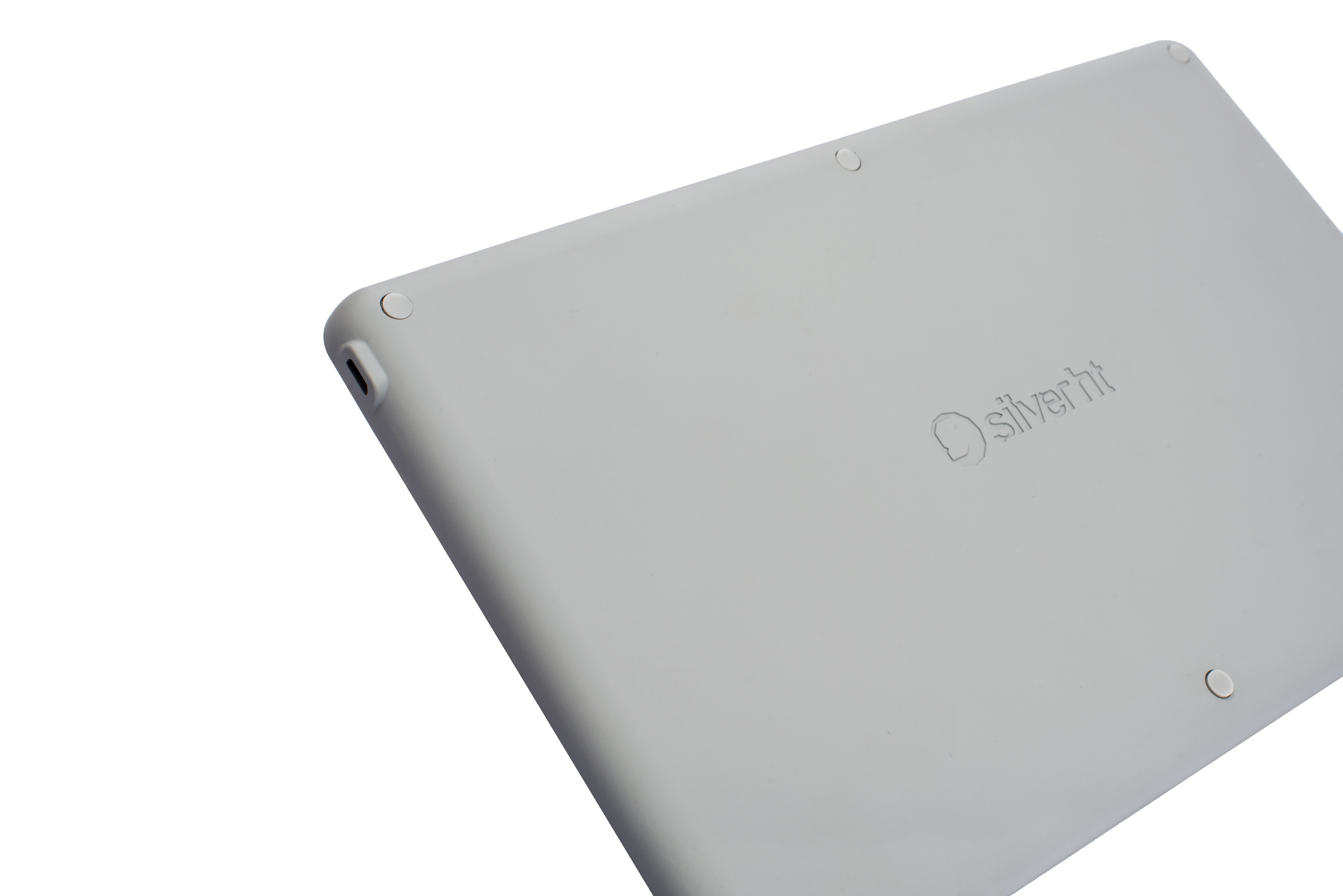 Szary tablet, tyłem do góry. Ma logo i dwie okrągłe nóżki. Białe tło.