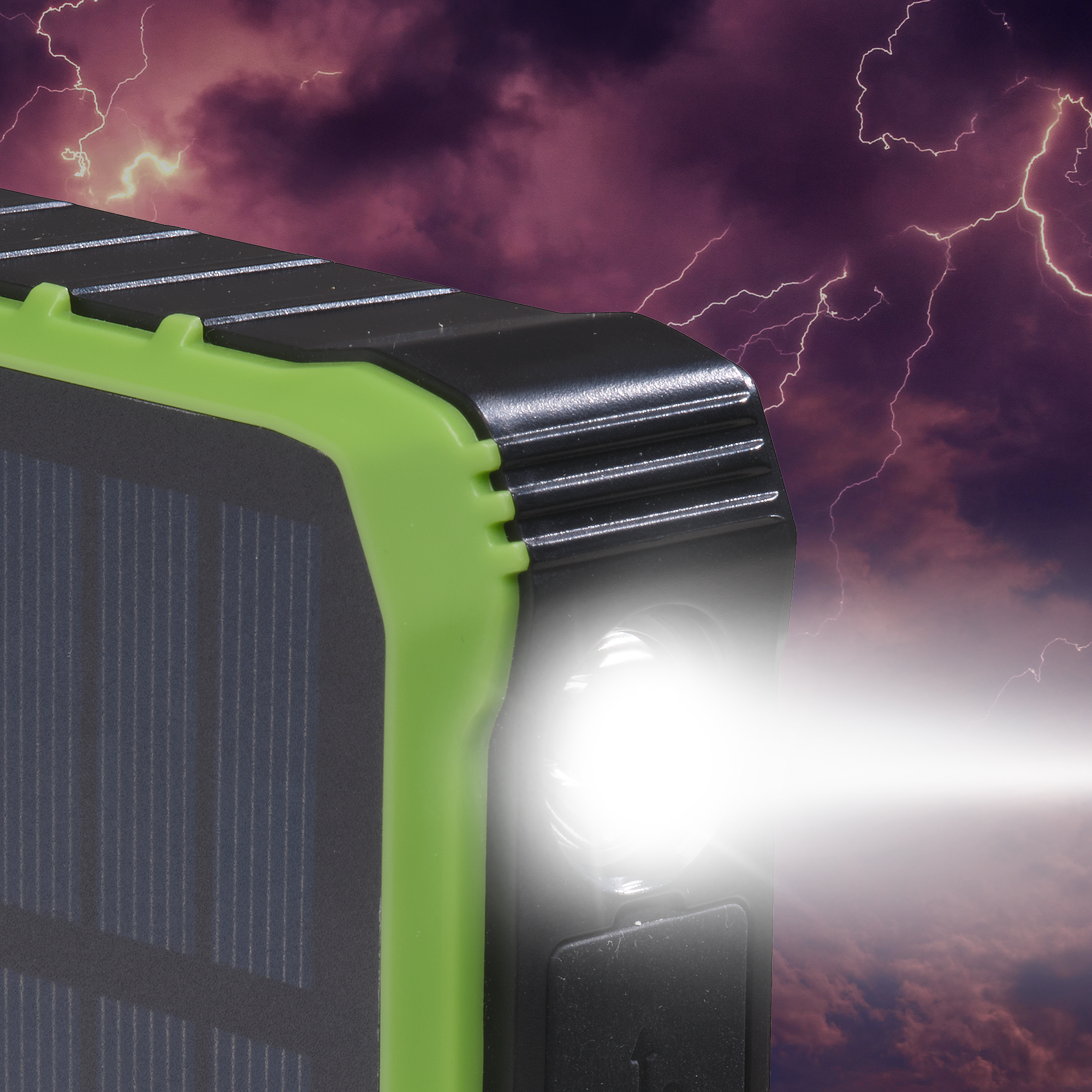 Chargeur solaire noir et vert. Une lumière vive brille de l'appareil sur un fond orageux.