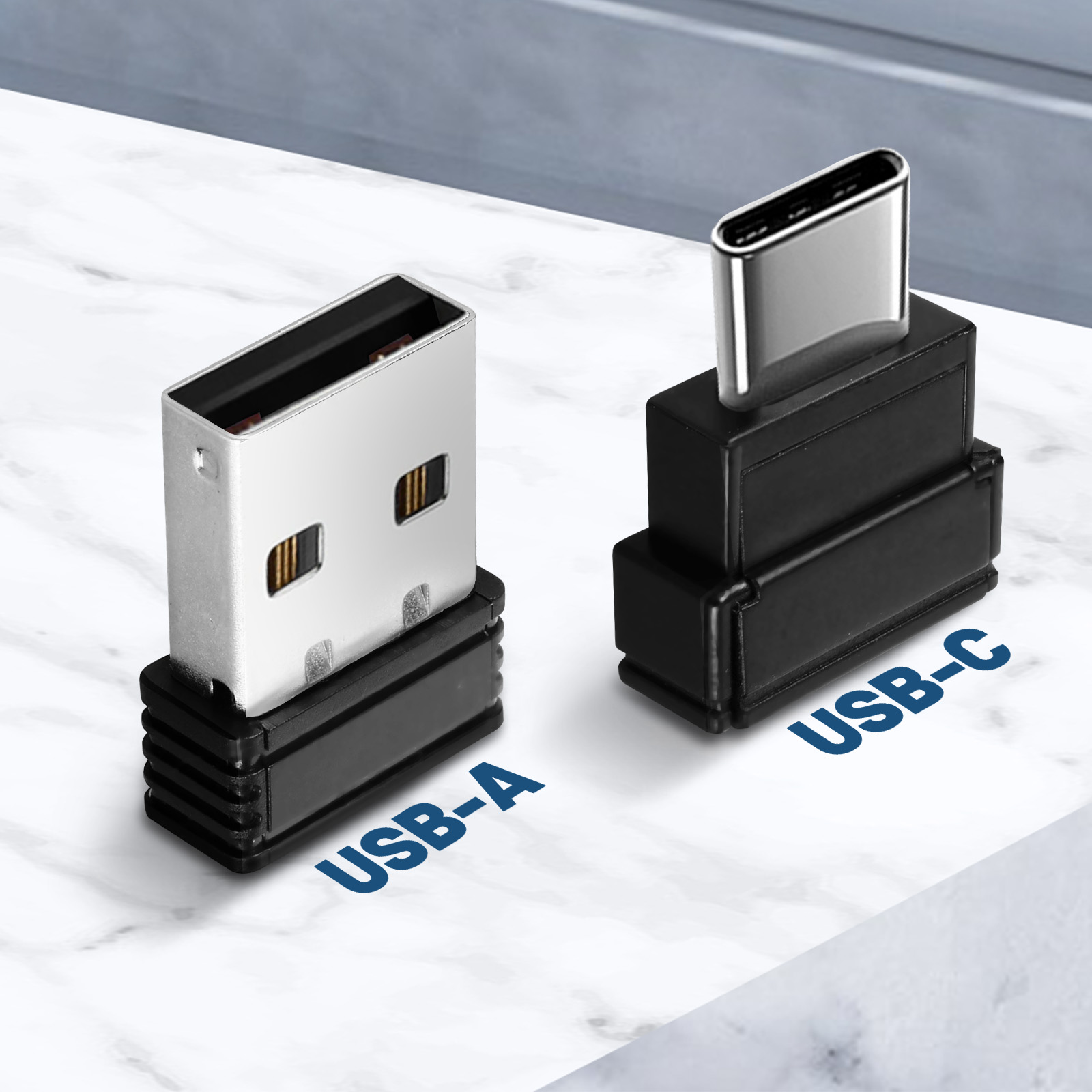 Adattatore USB-A a USB-C, con etichette USB-A e USB-C. Superficie in marmo bianco.