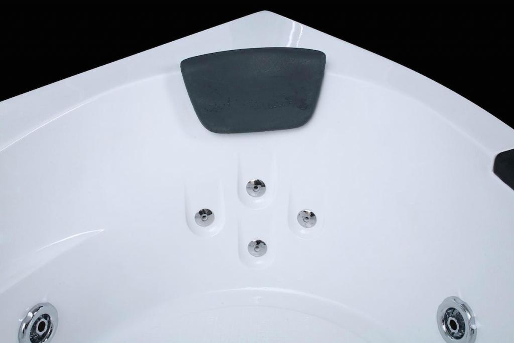 Weiße Ecke eines Whirlpools. Vier Wasserdüsen sind sichtbar. Schwarzer Hintergrund.