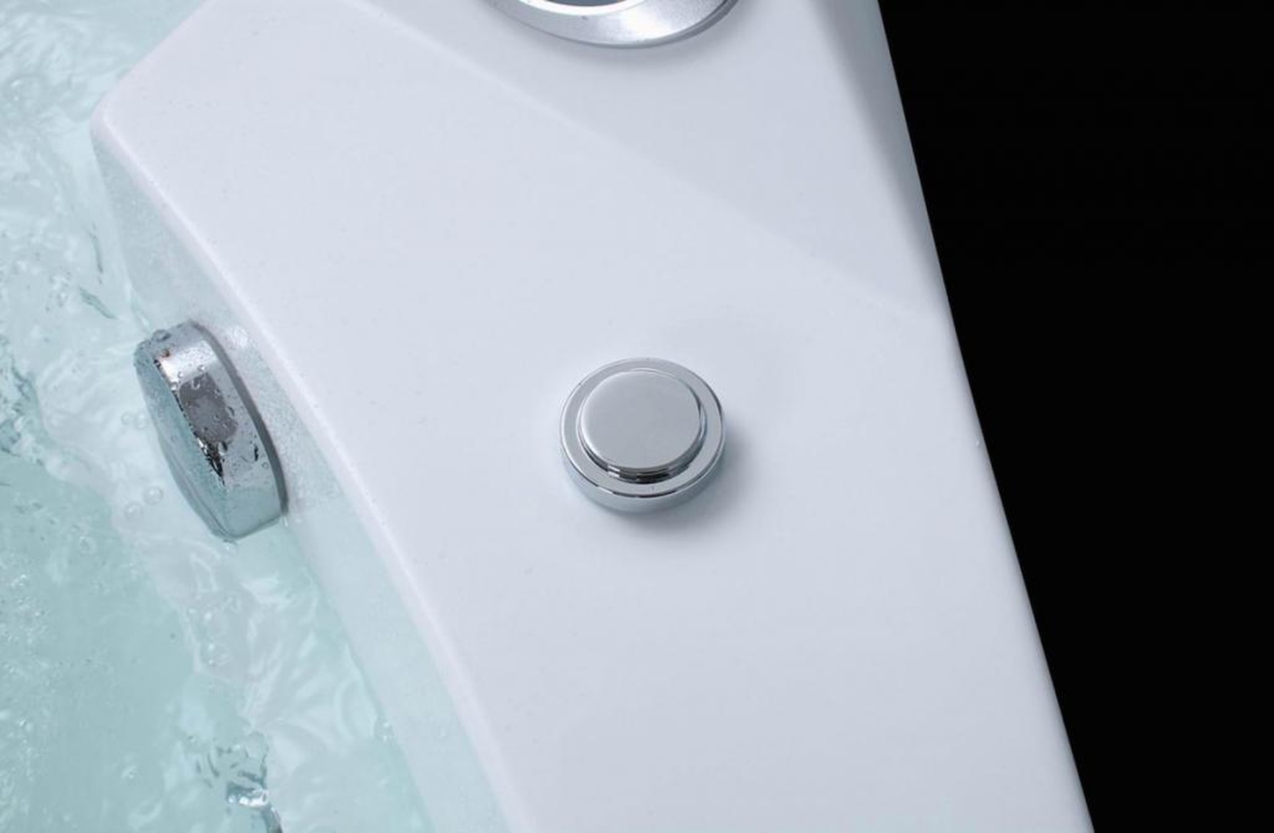 Nahaufnahme eines weißen Whirlpools mit zwei Chromknöpfen. Blasen sind im Wasser sichtbar.