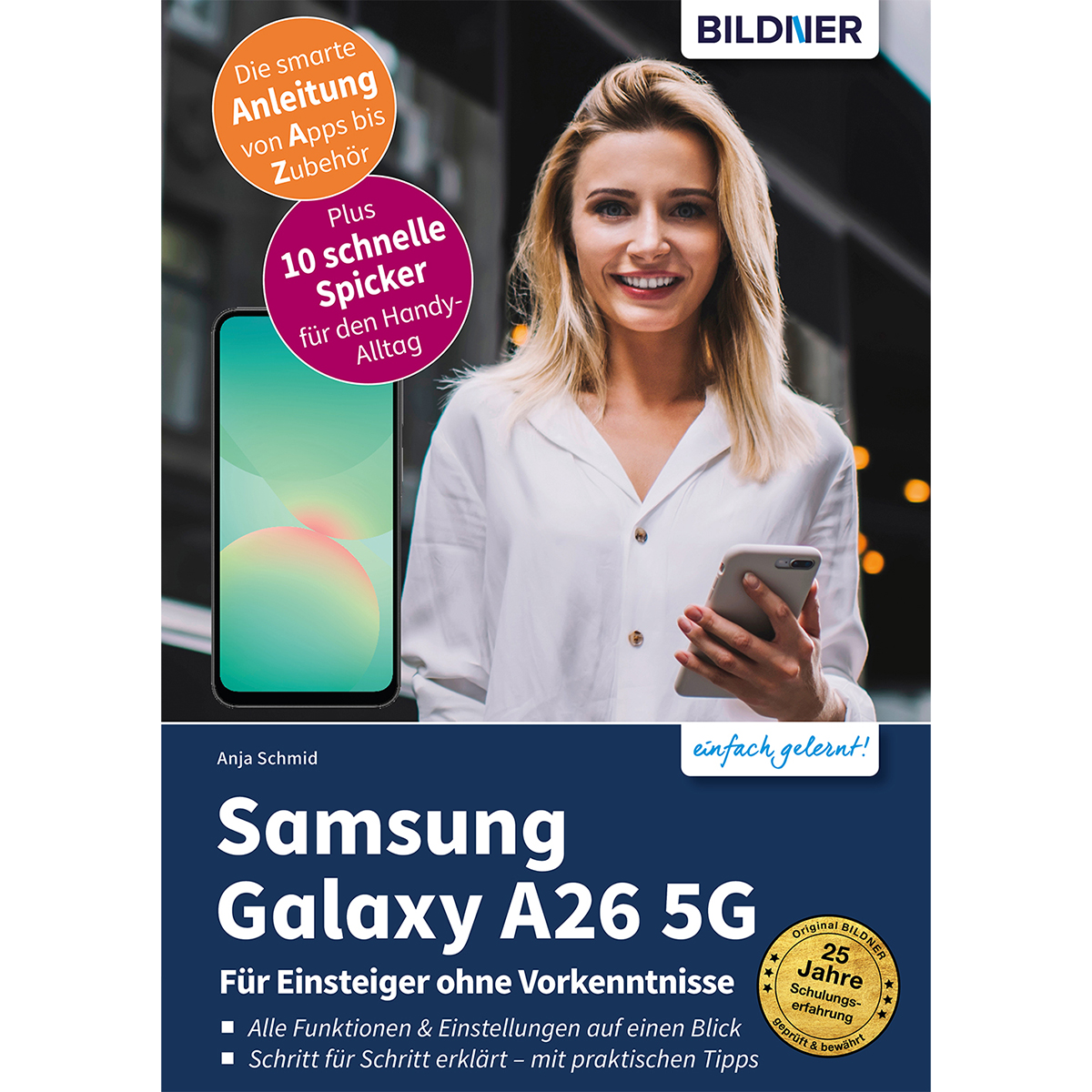 Eine Frau hält ein Telefon und ein Buch. Text auf dem Buch: 'Samsung Galaxy A26 5G'.