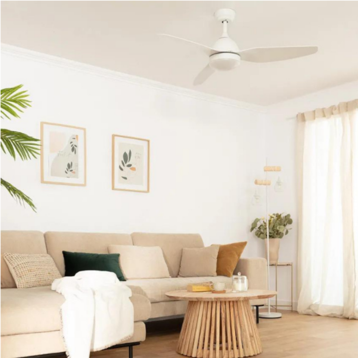Soggiorno con ventilatore a soffitto bianco, arte, tavolo da pranzo, sedie e decorazioni.