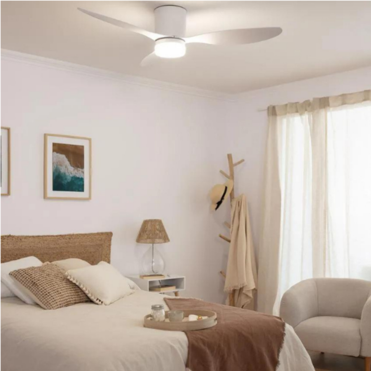 Ventilatore da soffitto bianco con luce in una camera da letto. Letto, dipinti, tende e sedia visibili.