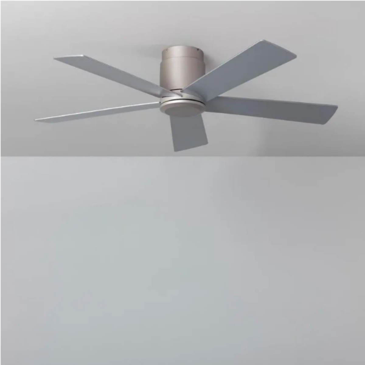 Ventilatore da soffitto argentato con cinque pale su sfondo grigio.