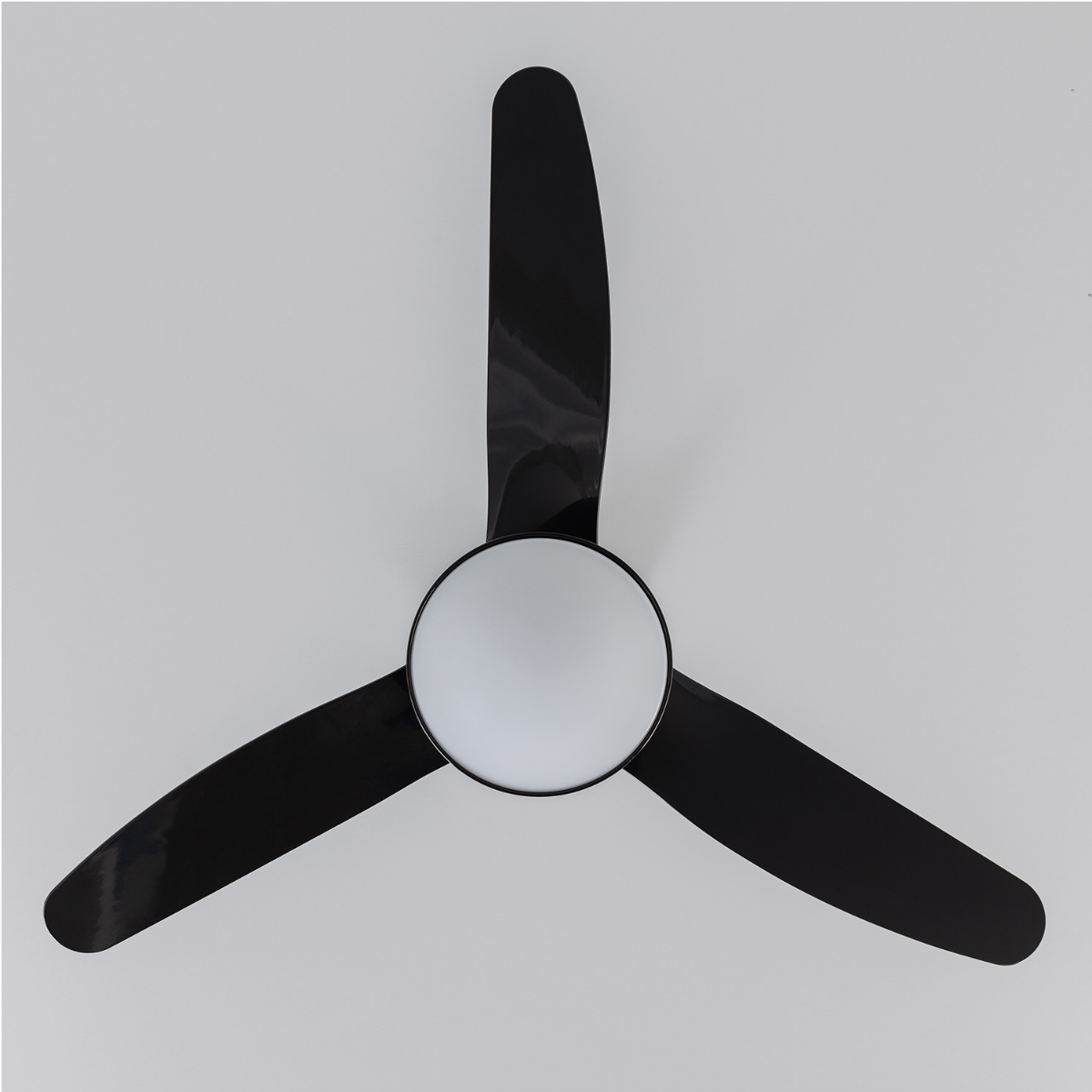 Ventilatore da soffitto con tre pale nere e una luce bianca al centro.