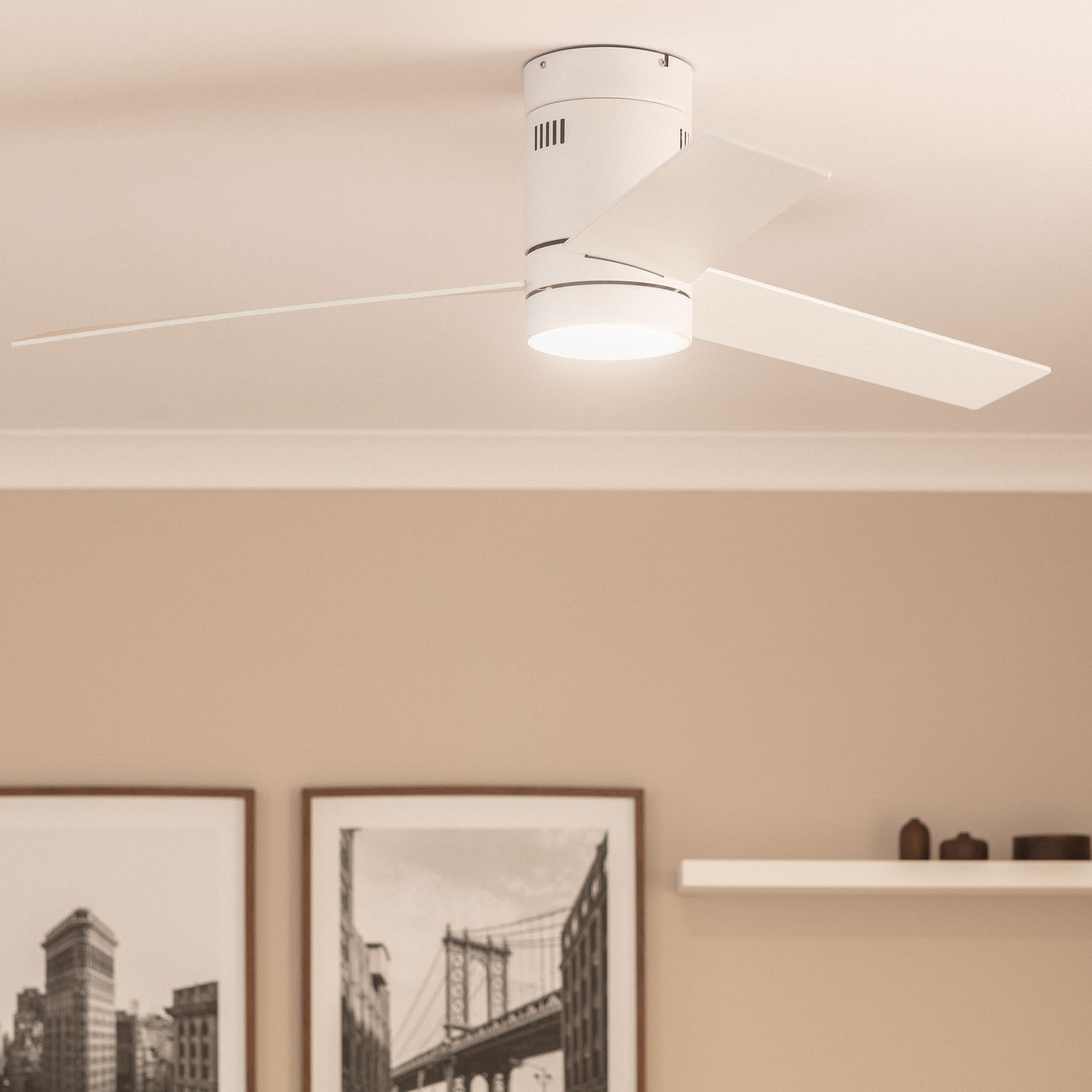 Ventilatore da soffitto bianco con luce, montato su un soffitto in una stanza con opere d'arte.