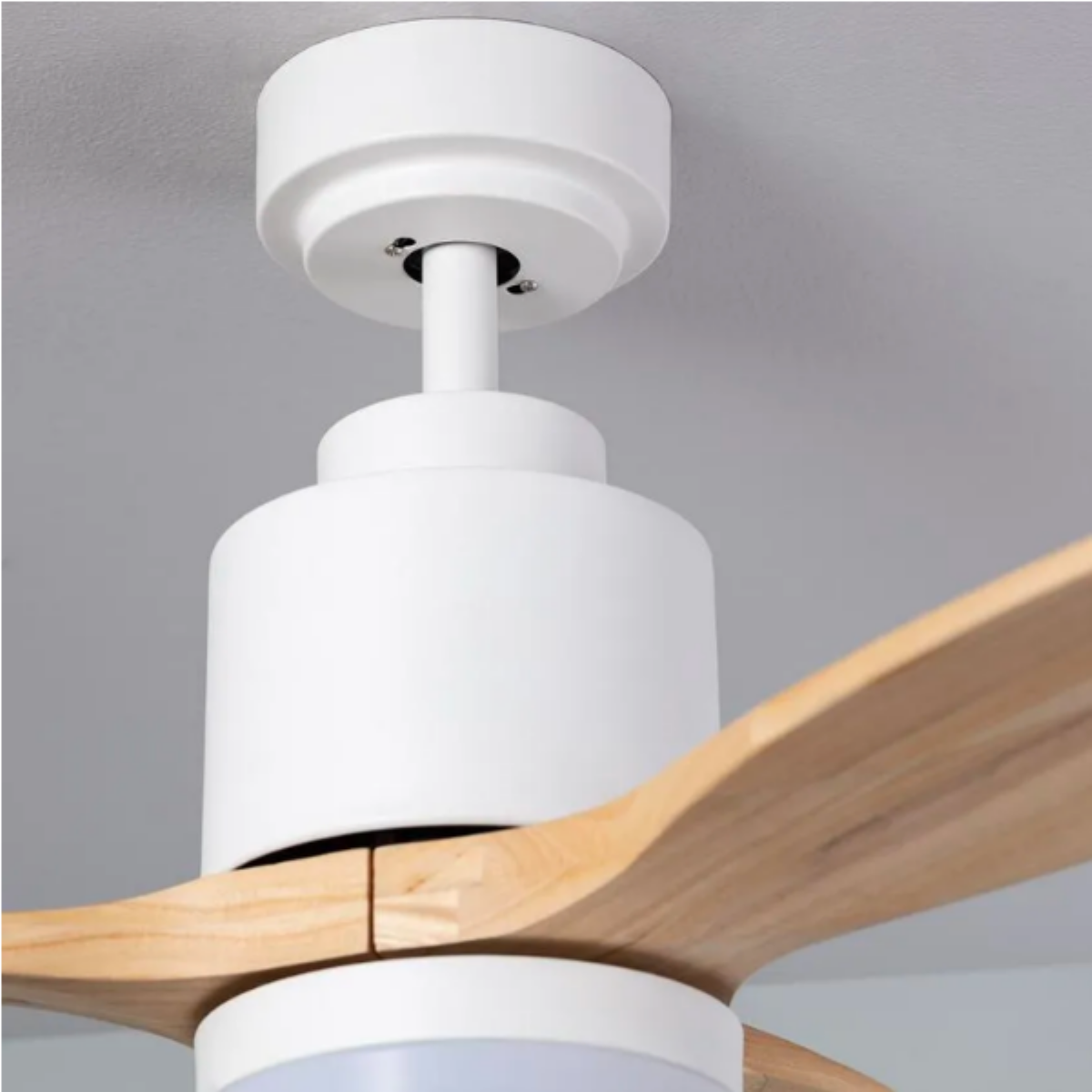 Un ventilatore da soffitto bianco con pale in legno. Il ventilatore ha un'apparecchio di illuminazione.