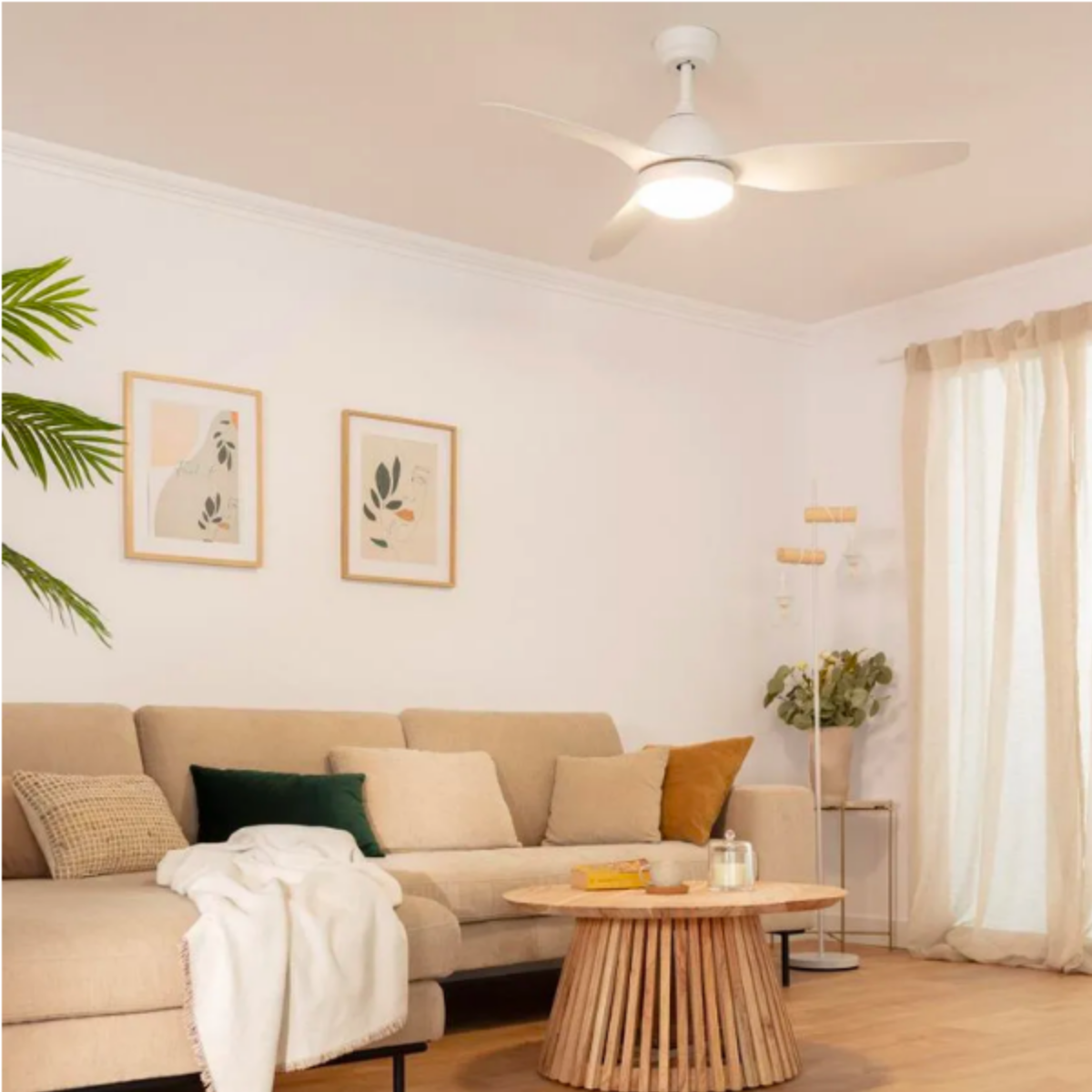 Ventilatore da soffitto bianco in soggiorno con mobili, arte e un tavolo rotondo.