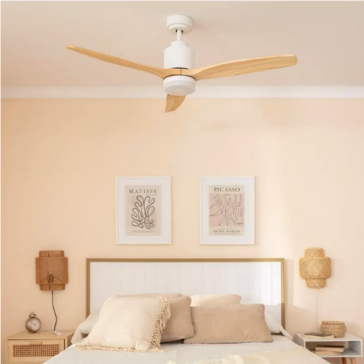 Camera da letto con ventilatore da soffitto, letto, arte. Pareti color pesca chiaro.