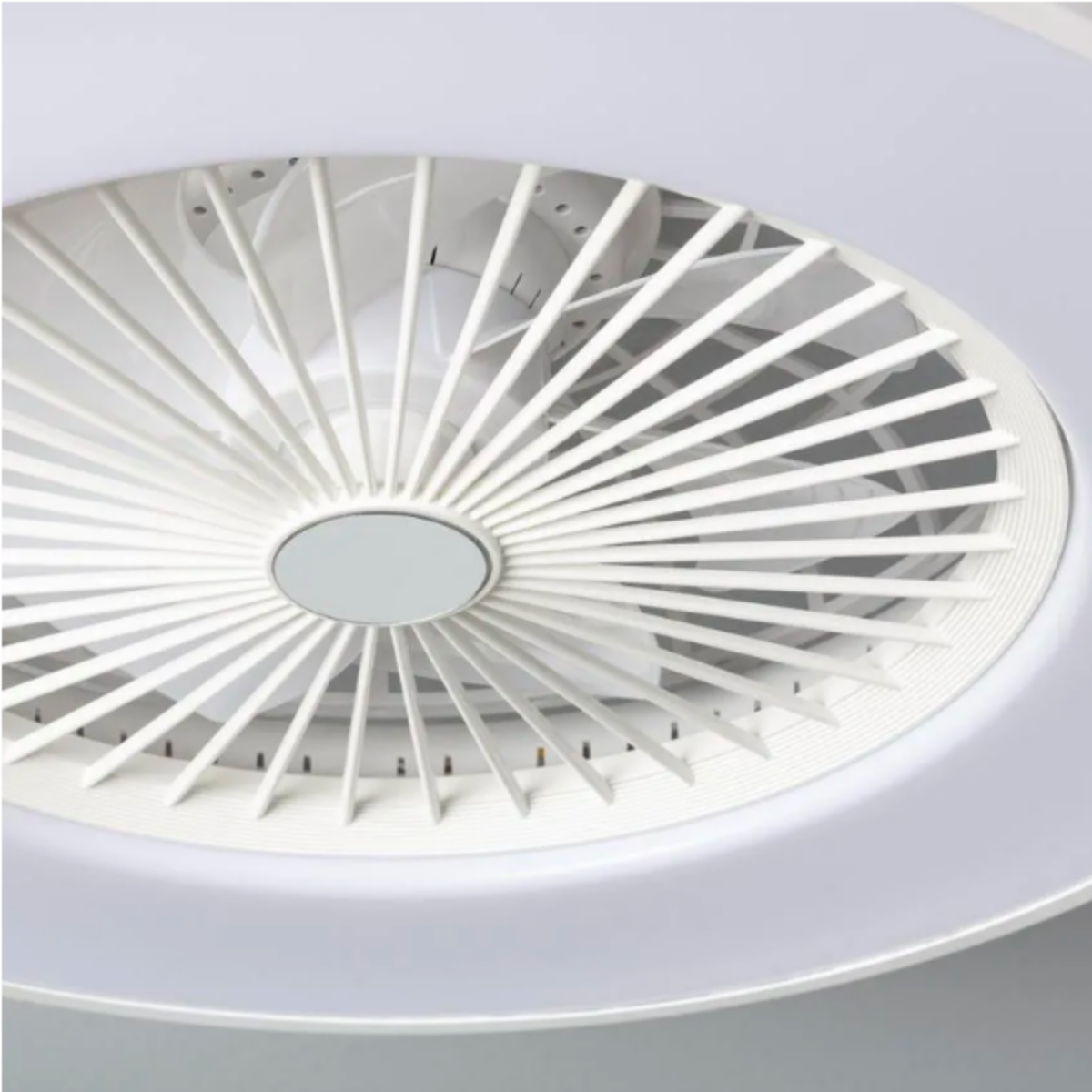 Vista dal basso di un ventilatore da soffitto bianco con molte pale. Luce integrata brillante.