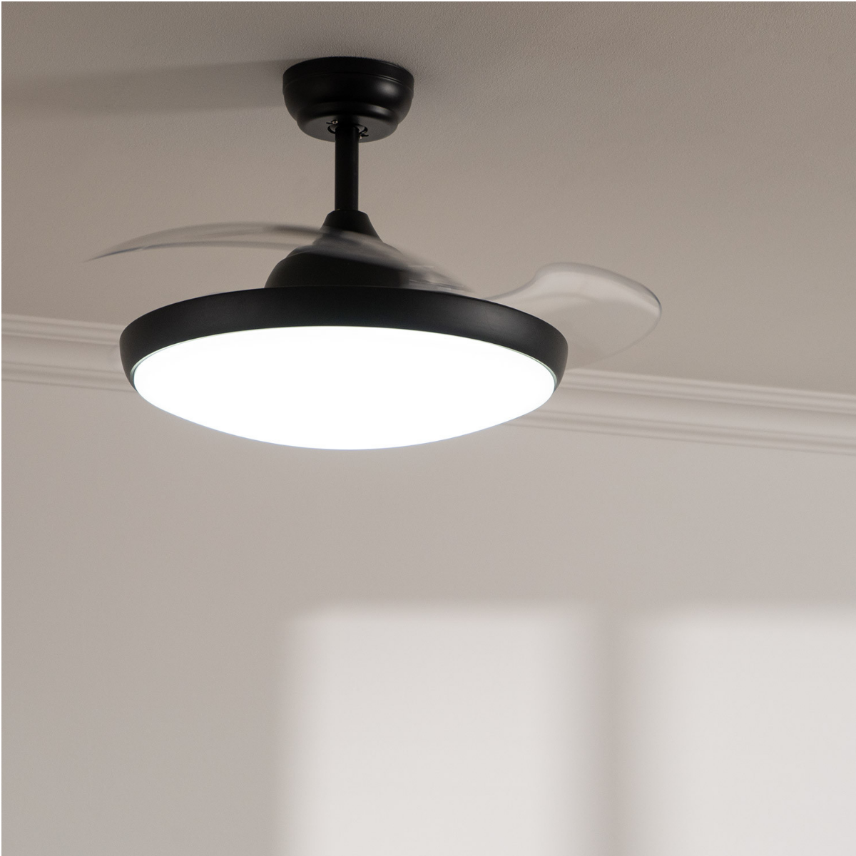 Ventilatore da soffitto nero con luce integrata, ruotante su soffitto chiaro.