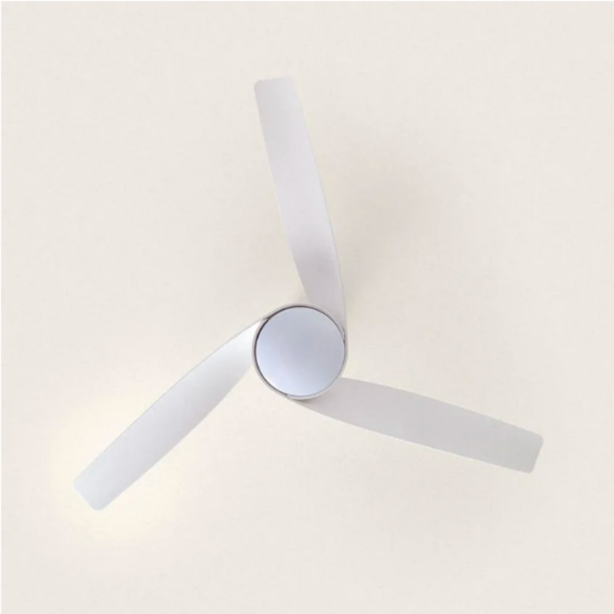 Un ventilatore da soffitto con tre pale grigie è montato su un soffitto di colore chiaro.