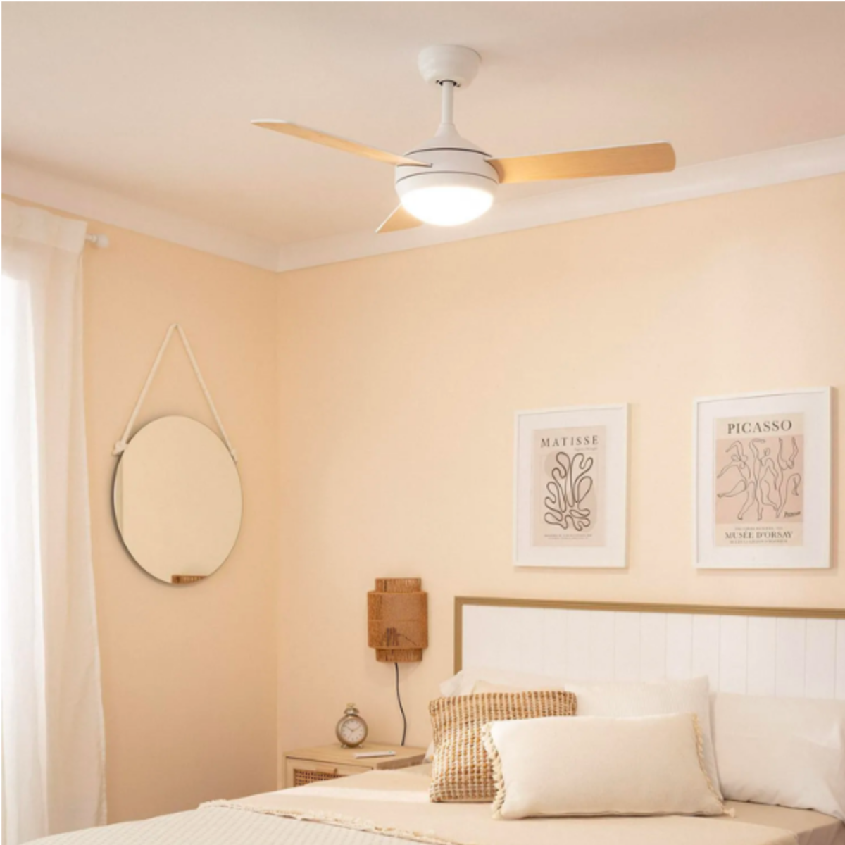 Camera da letto con ventilatore da soffitto, letto, arte. Pareti color pesca chiaro.