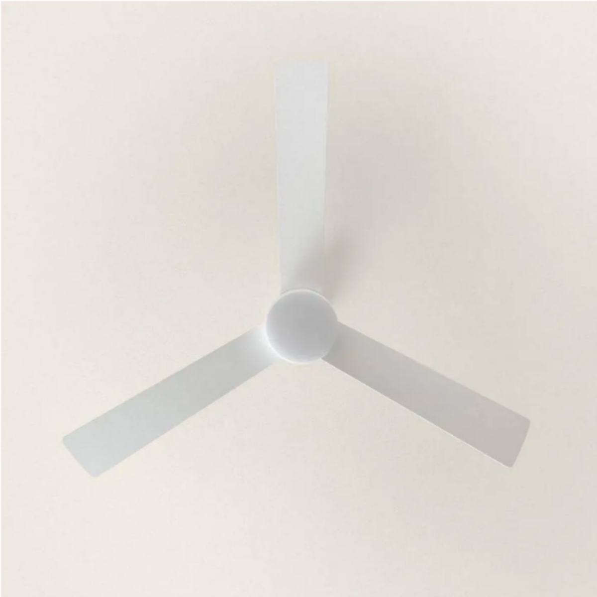 Un ventilatore da soffitto con tre pale grigie contro un soffitto di colore chiaro.