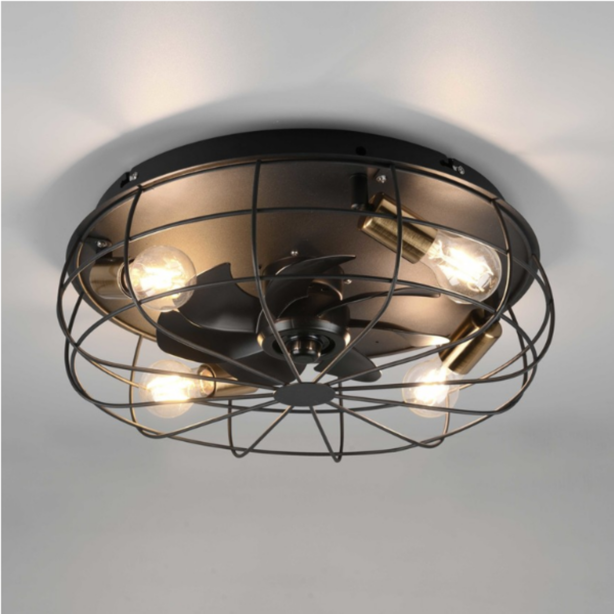Ventilatore da soffitto in stile industriale con quattro lampadine. Montato su un soffitto bianco.
