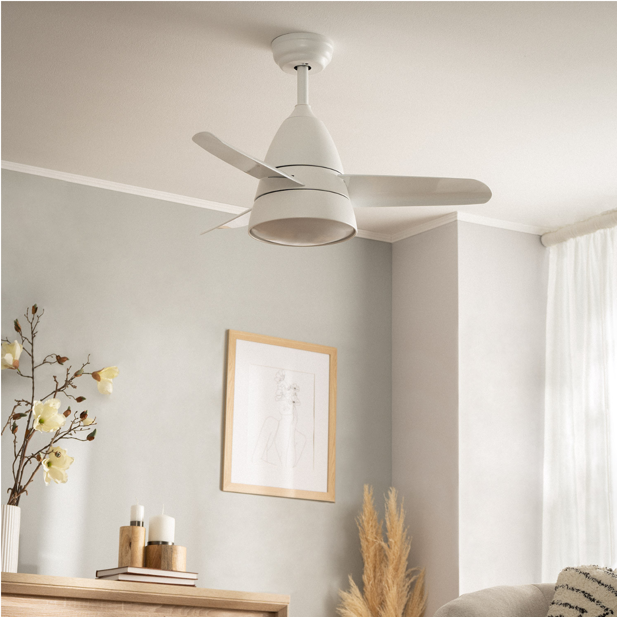 Un ventilatore da soffitto bianco. Una parete decorata con una cornice e altri oggetti sono visibili.