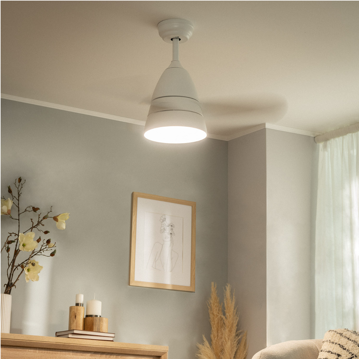 Ventilatore da soffitto bianco in una stanza con un'immagine incorniciata e decorazioni. La stanza ha pareti grigie.