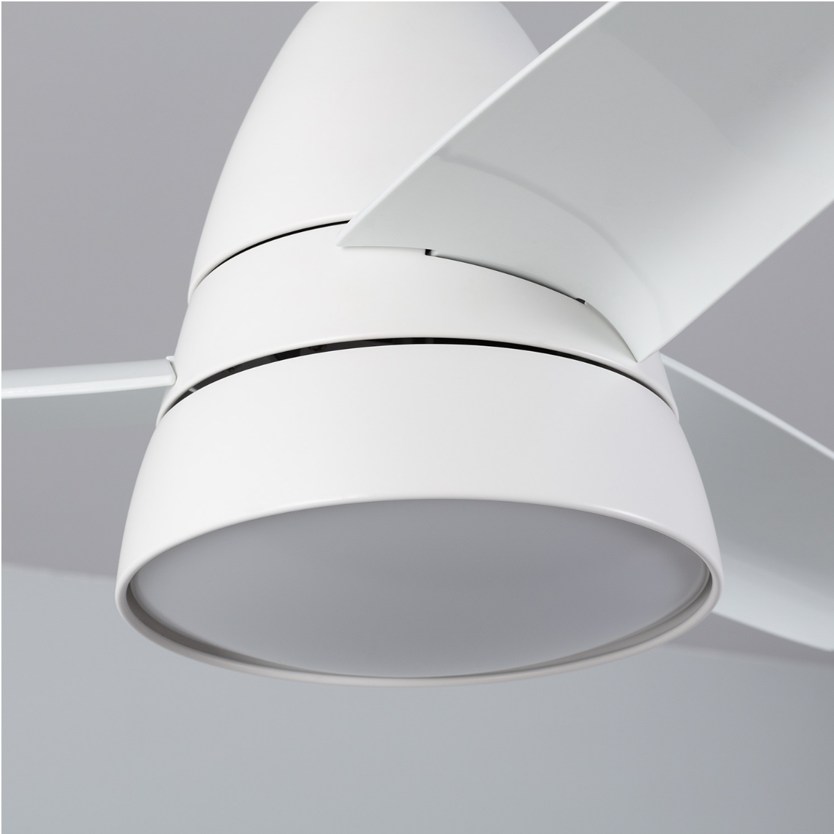 Primo piano di un ventilatore da soffitto bianco con una luce in basso. Pale bianche.