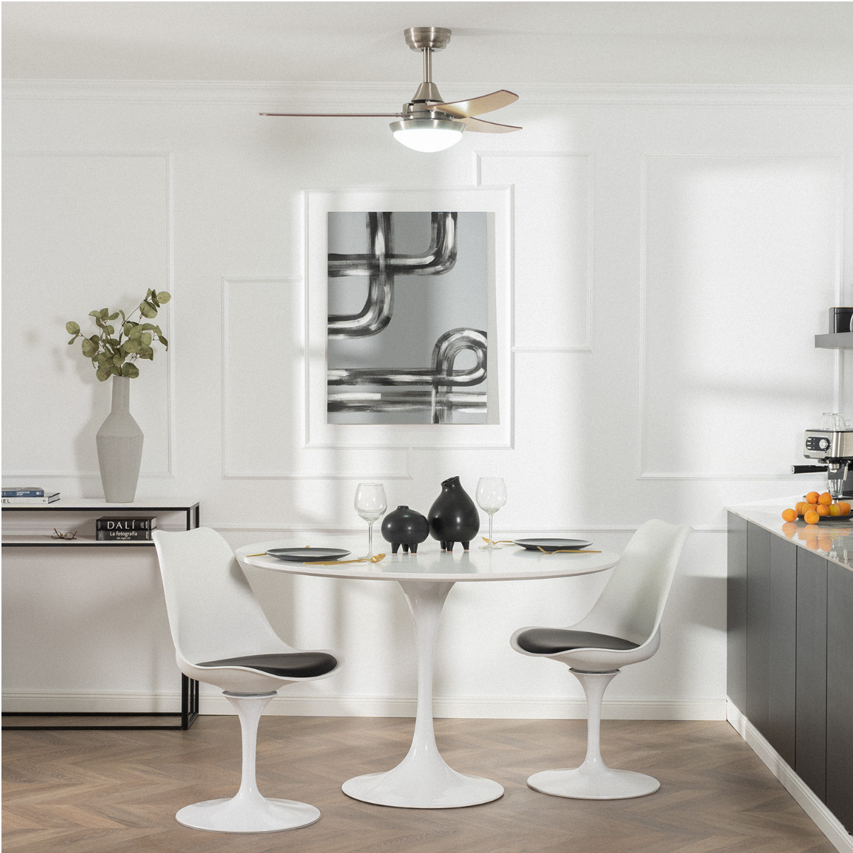 Sala da pranzo con tavolo, sedie e ventilatore da soffitto. Design moderno con arte sulla parete.