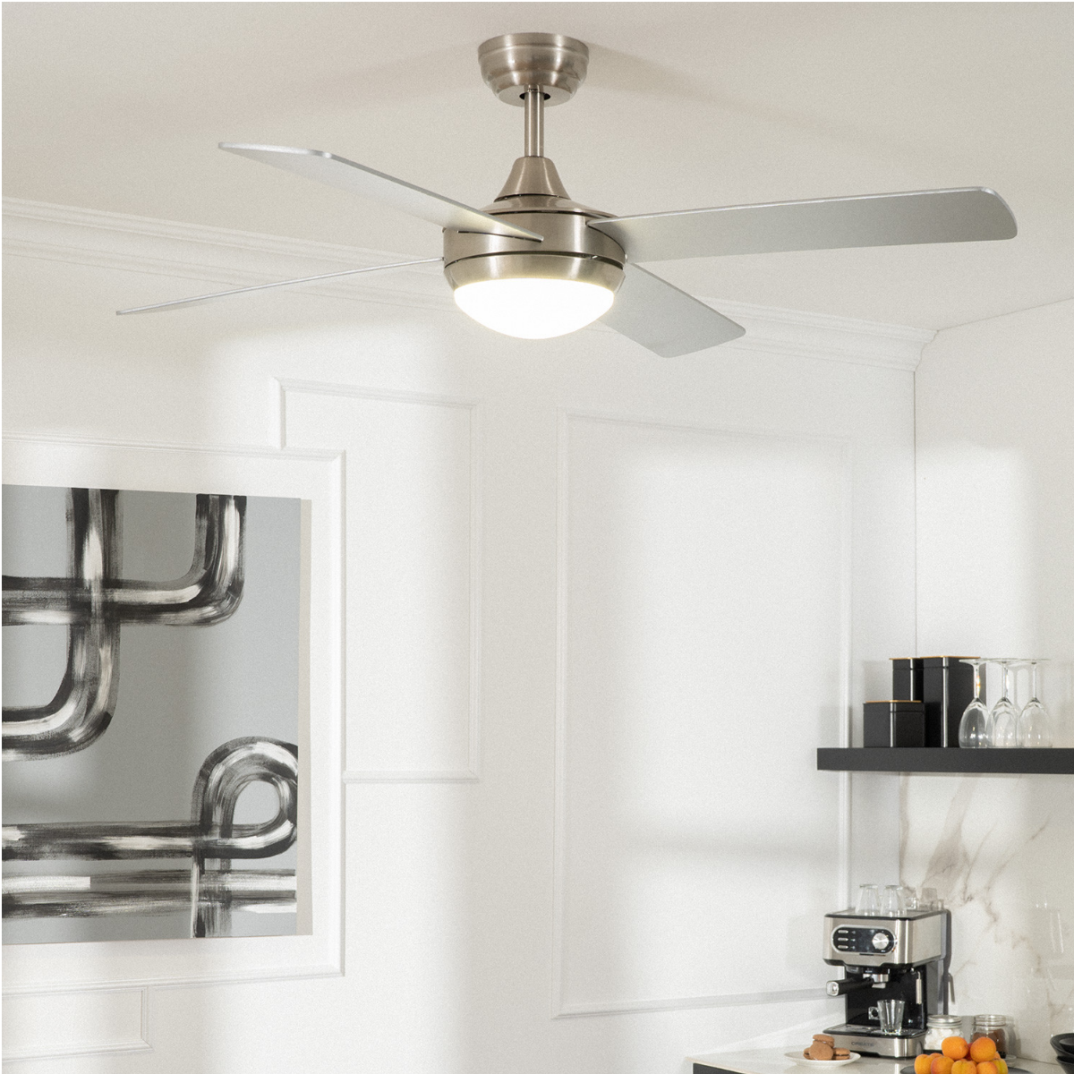 Ventilatore da soffitto con luce e quattro pale argentate, montato in una stanza bianca con arte.