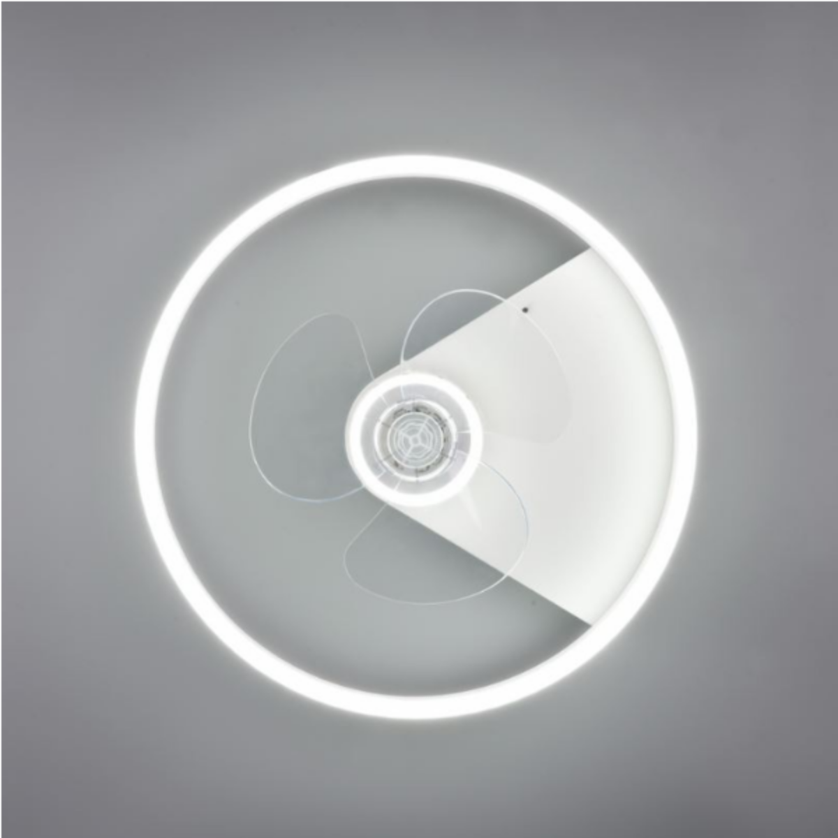 Un ventilatore a soffitto con una luce ad anello su sfondo grigio. Il ventilatore ha tre pale visibili.