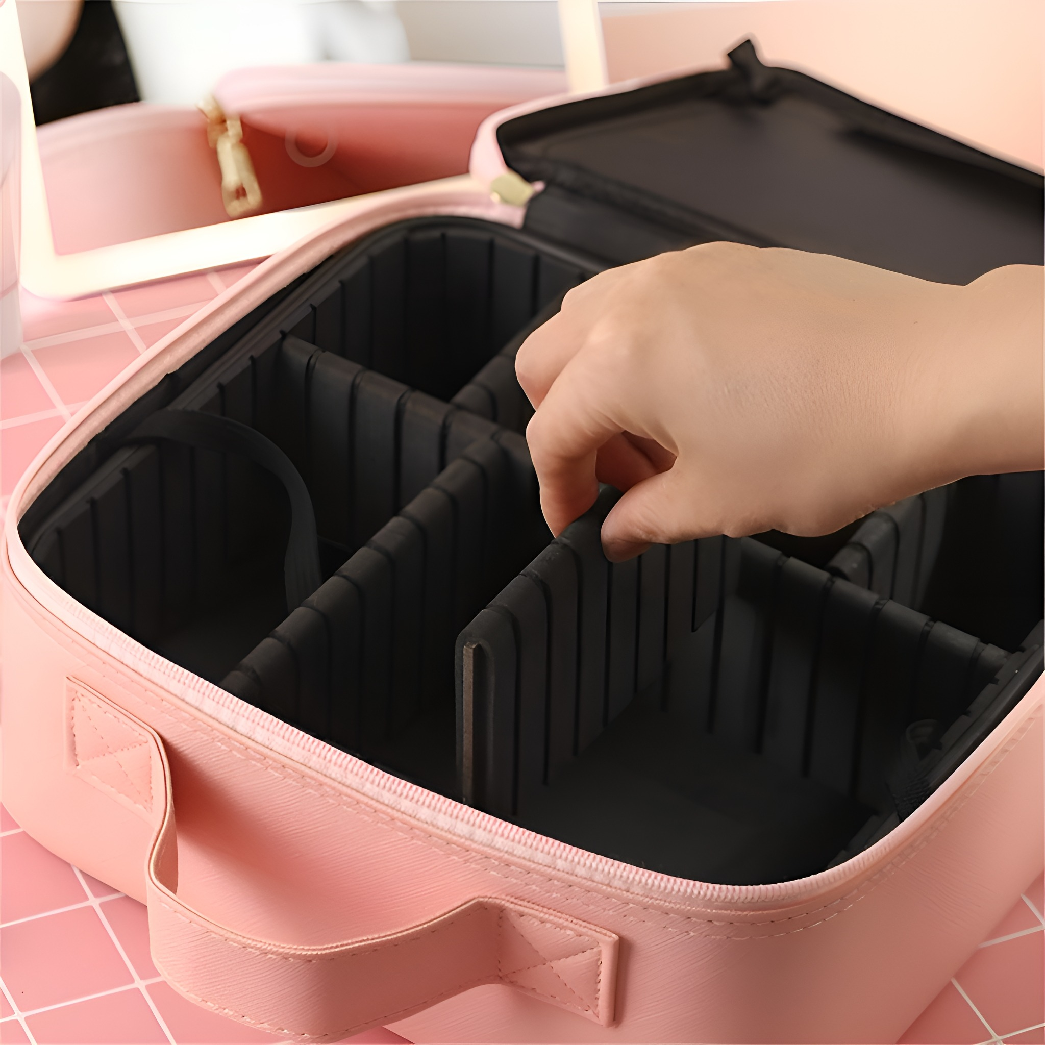 Offene rosa Make-up-Tasche, mit Trennwänden und einer Hand, die sie einstellt.